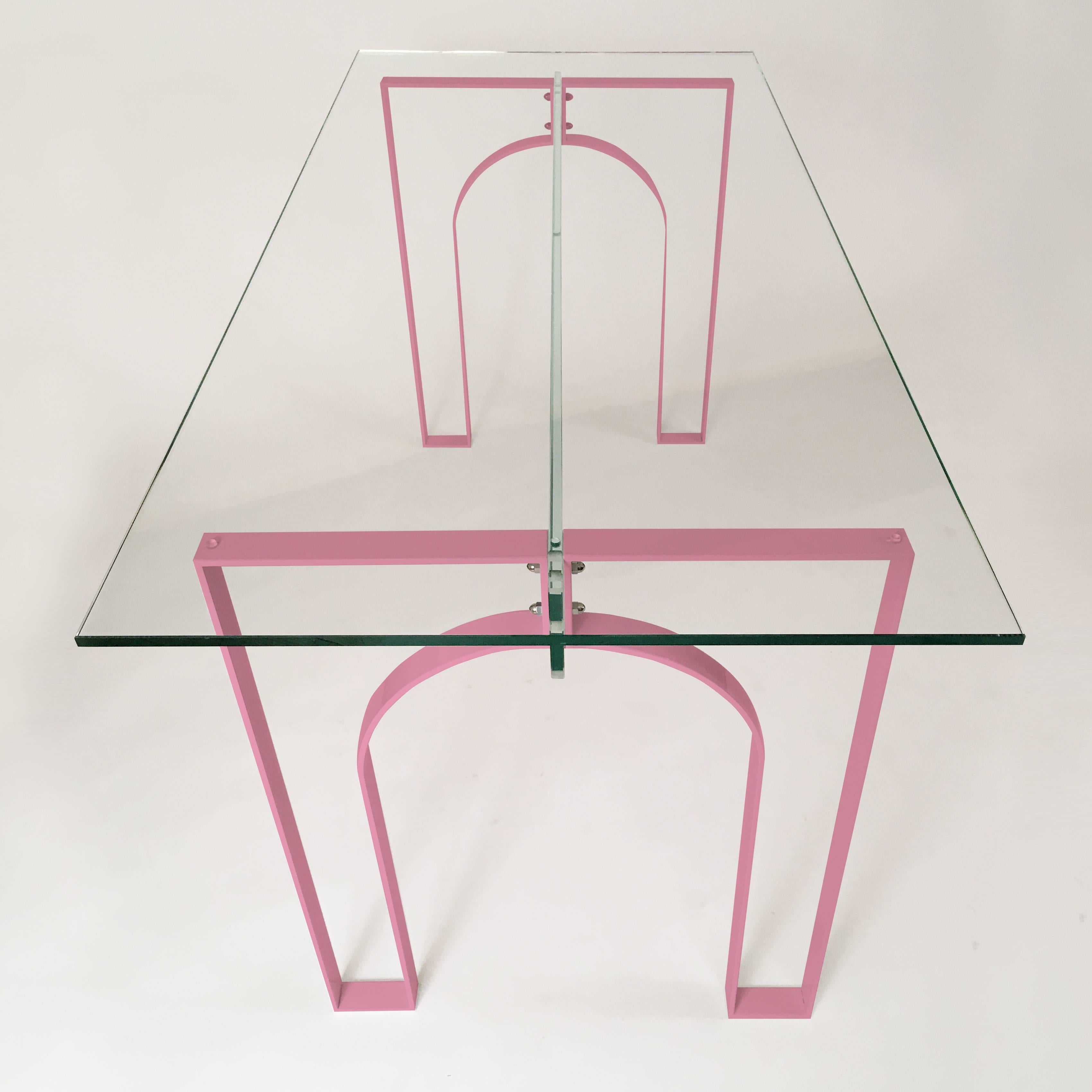 Minimal and modern, this desk shows that simple is beautiful. It is constructed of custom bent steel legs that form arches on either end and a glass connecting beam across the middle. The legs are powder-coated and can be provided in any RAL color