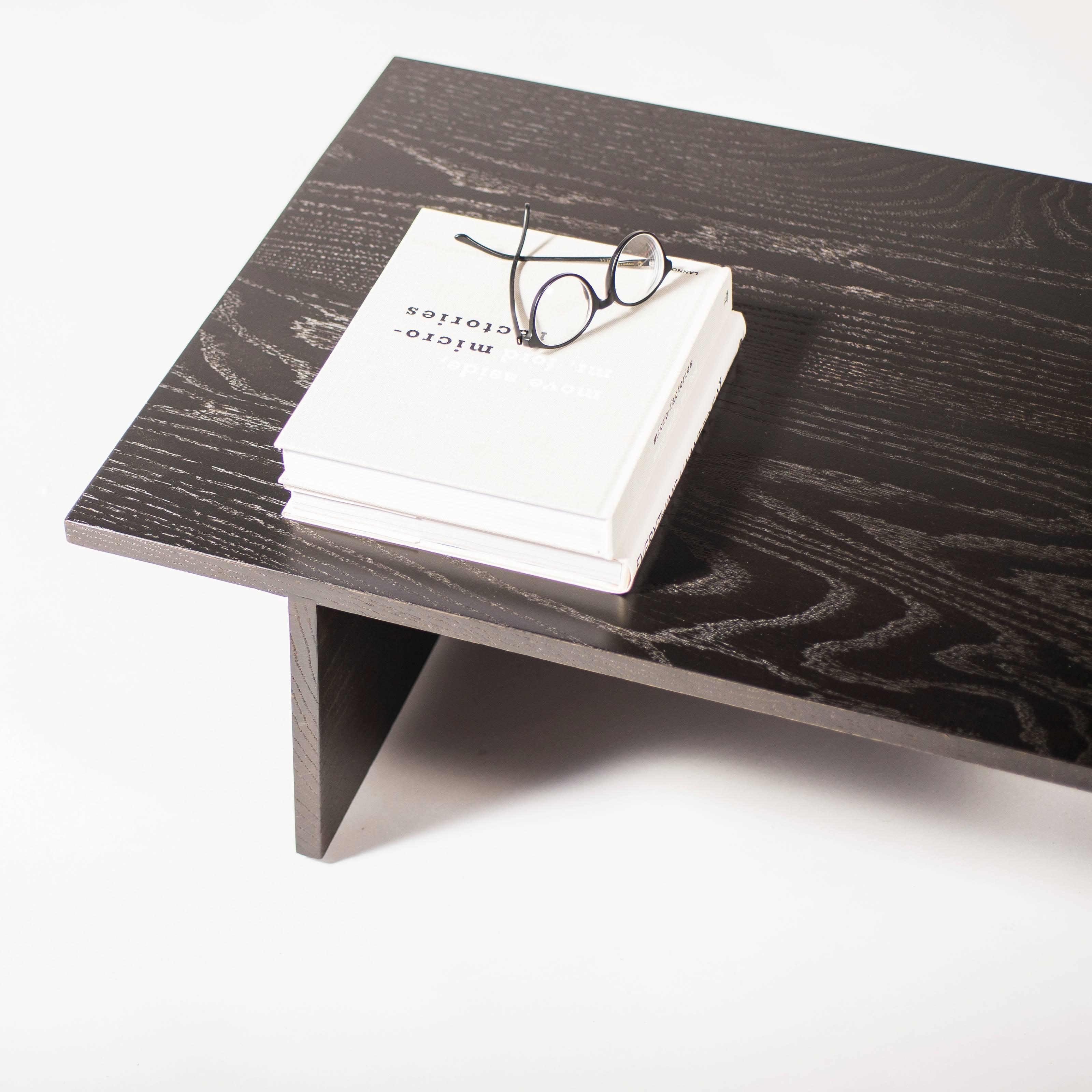 Cette table basse met l'accent sur la simplicité et la beauté naturelle du bois. Qu'il soit naturel ou en finition laquée noire, les veines de ce plateau de table contemporain en chêne séduisent l'esprit et détendent le corps. Simple.
