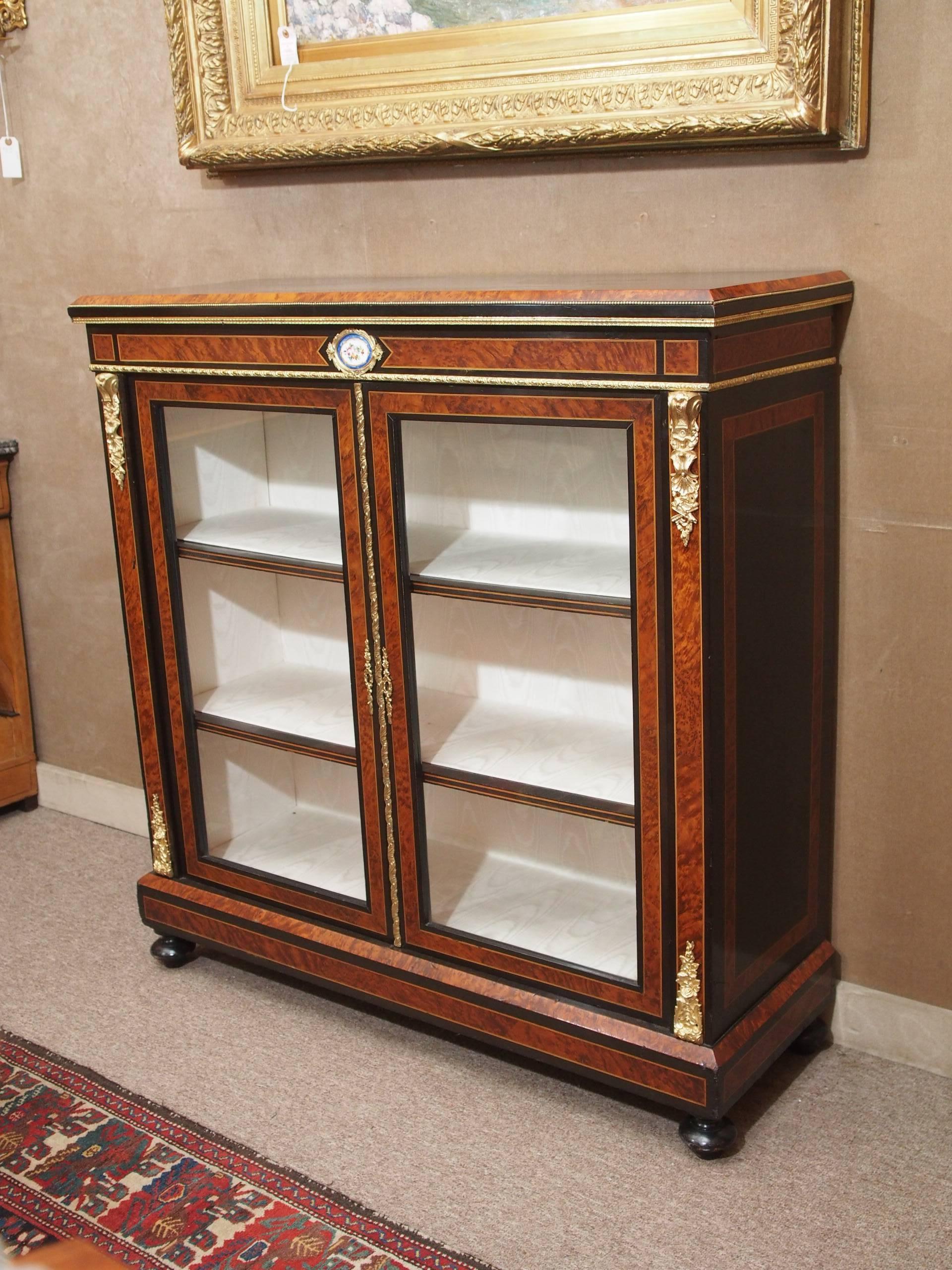 Antique English briarwood and ebonized cabinet, circa 1860. This piece is lovely and has a beautiful little floral plaque in the center above the doors. The cabinet came to us with its lined interior.