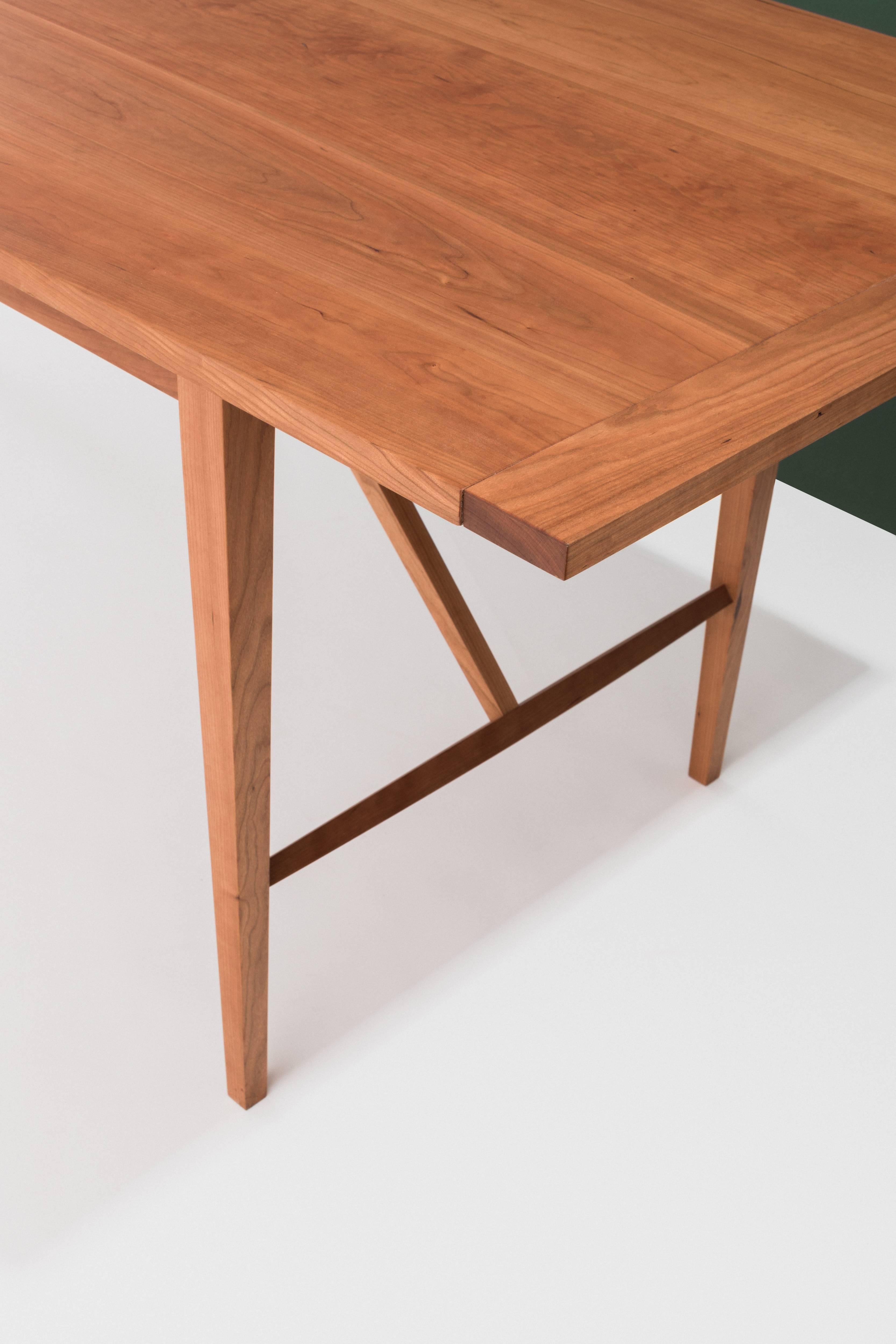 This lightweight yet sturdy dining table draws from Classic farm and Shaker table design. The slim profile and slightly shaped and tapered legs lend an elegance to the piece. 

Pictured in cherry and additionally offered in walnut and maple.