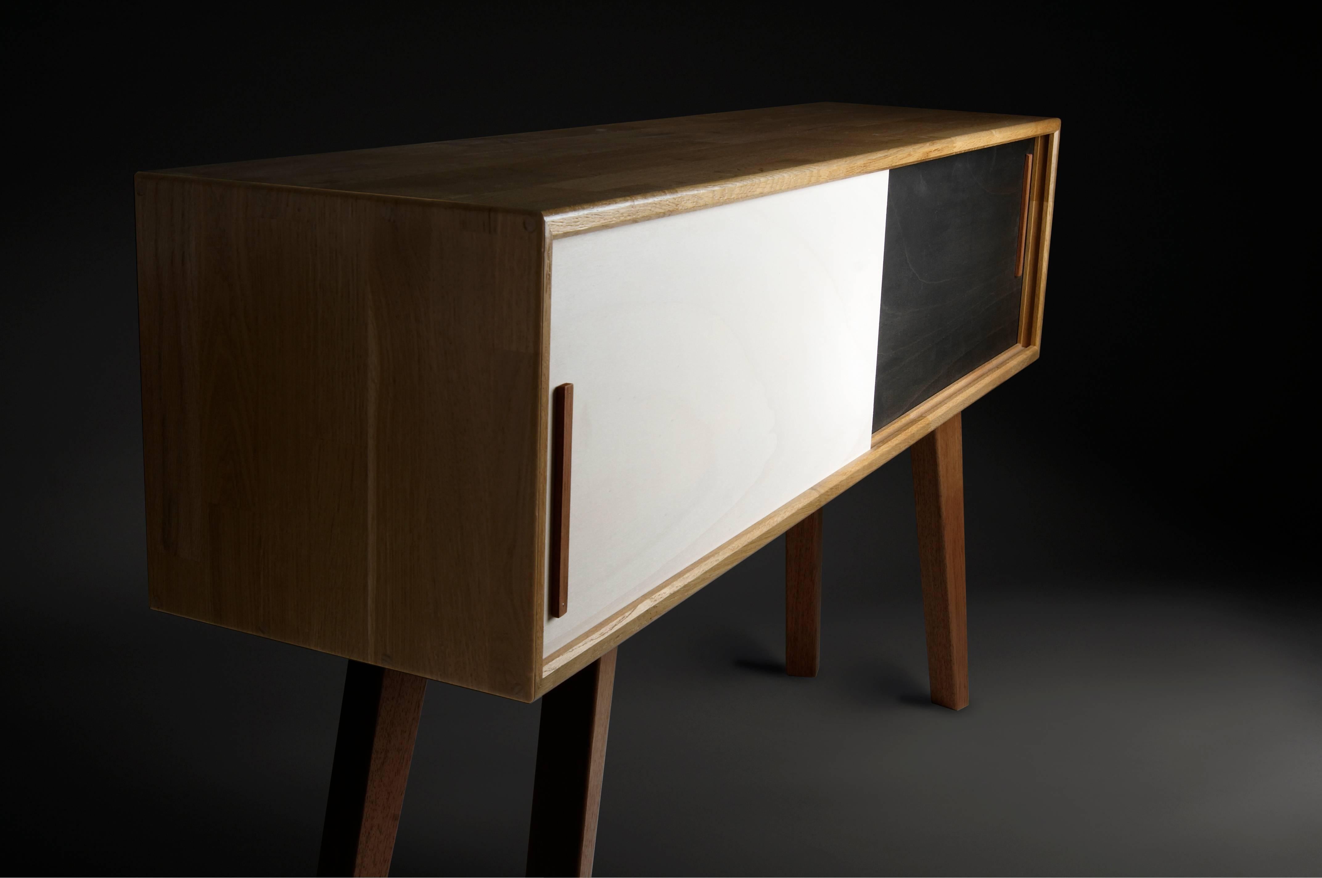 Sideboard cabinet in solid oak with sliding doors, elegance and purity of the lines,
for this ornamental furniture with irreproachable finishes,
black and white facade.
Ecological varnish.
Designed and manufactured by Julien Ebeniste