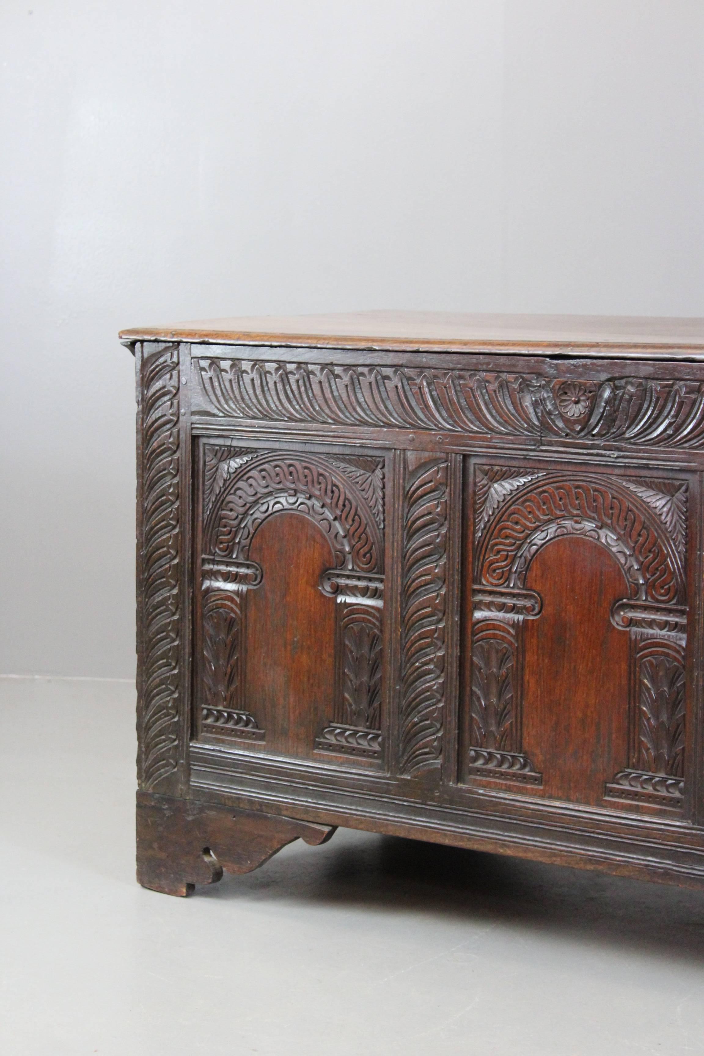 Antique oak coffer. 18th century carved oak coffer with hinged lid, plant hinged lid with three arcaded panels to the front and bracket feet. Quality craftsmanship and a very useful and practical storage item that could be used throughout the