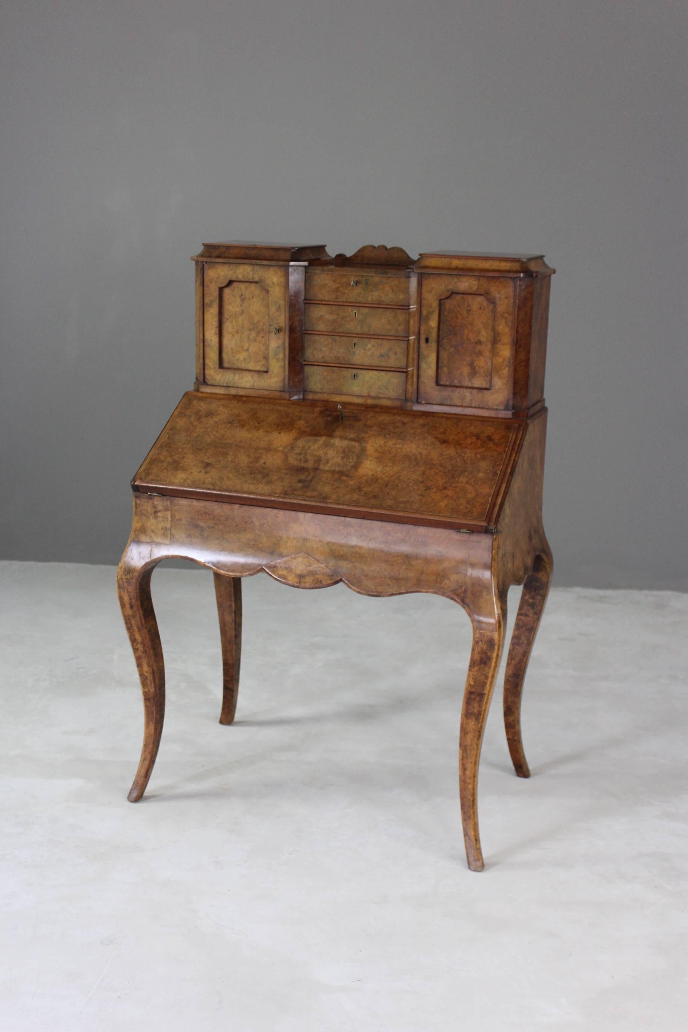 Burr walnut Bonheur du jour. Antique early 20th century small, French ladies writing table with four small drawers flanked by cupboards enclosed by panelled doors & lined with faded red velvet, fall front writing surface with red leather inset,