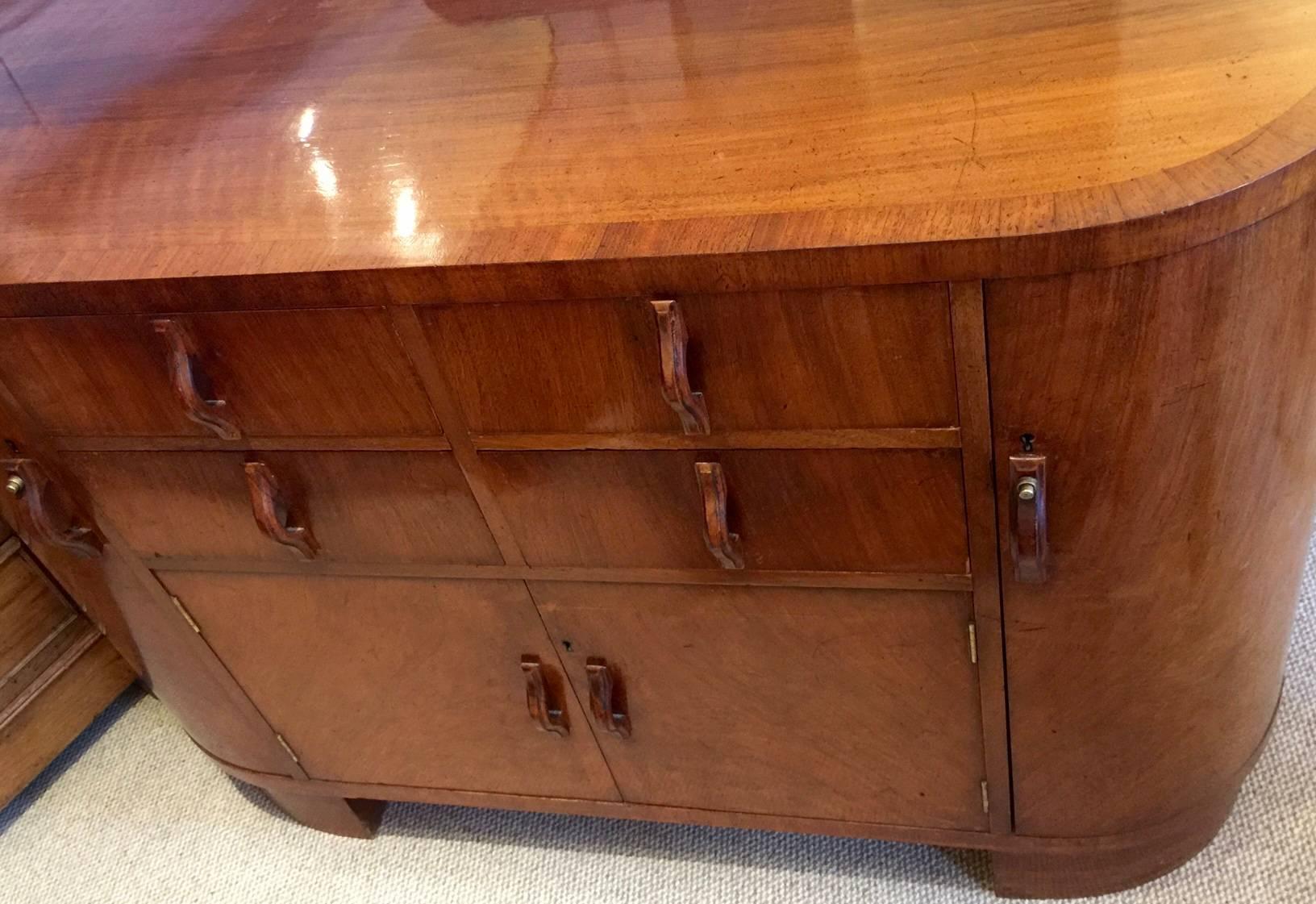 A stunning Art Deco cocktail cabinet dated 1936. Classic Art Deco lines and beautifully constructed. An attractive and functional piece with the Mahogany cross banded top above four drawers and two cupboards flanked either side with drinks cabinets.