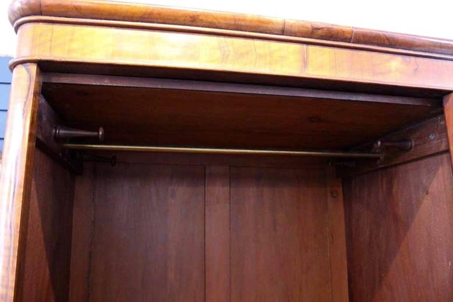 Handsome Victorian walnut wardrobe of good proportions. Attractive cornice above an arched centre panelled door.
Enclosed hanging rail and four original hanging pegs above a large single drawer with pretty turned knobs for handy storage.
In good