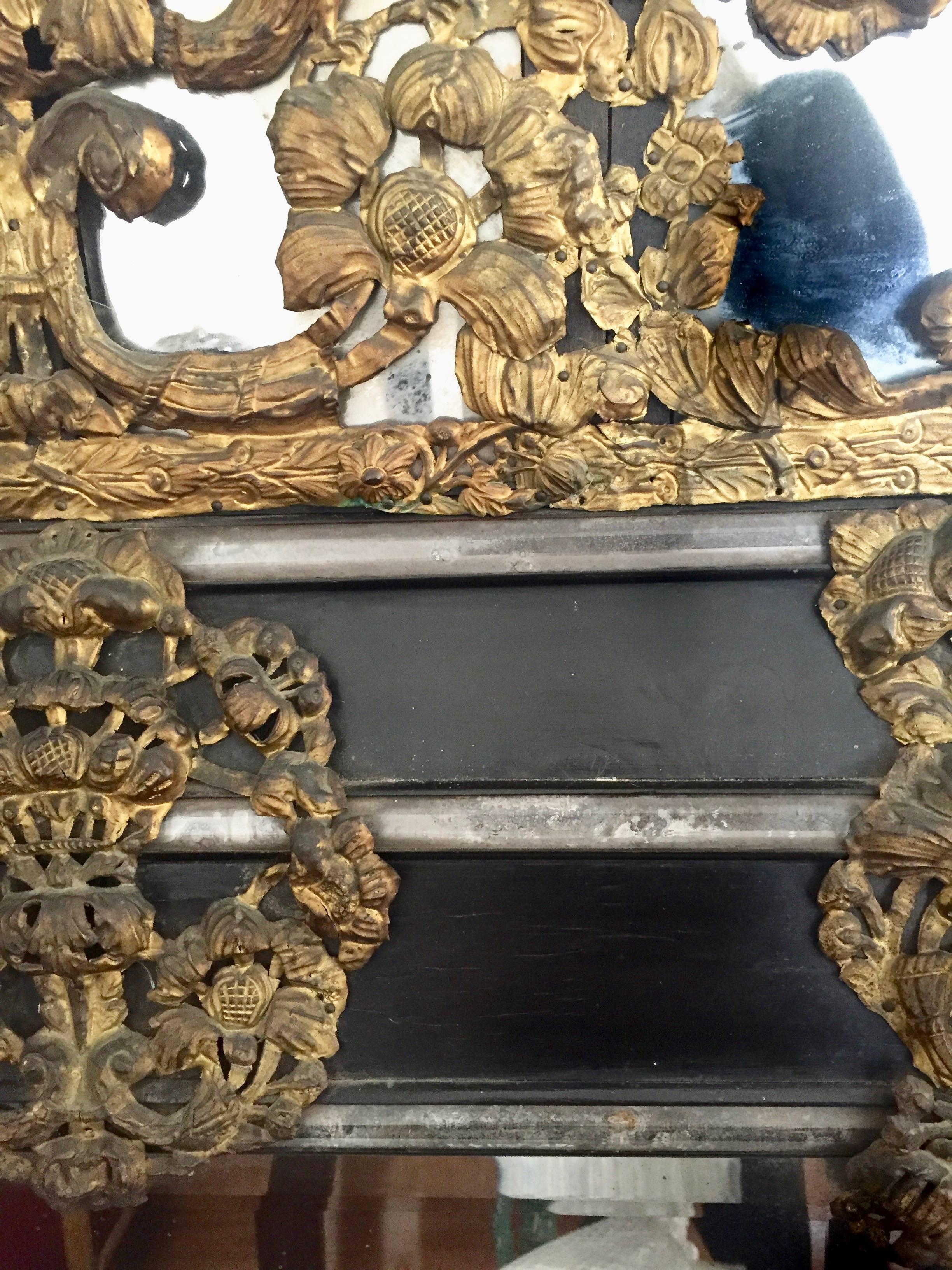 Flemish 17th century cushion mirror with gilt repouse brass work and cut mirror baguettes to the ebonized frame Flamande, circa 1680.