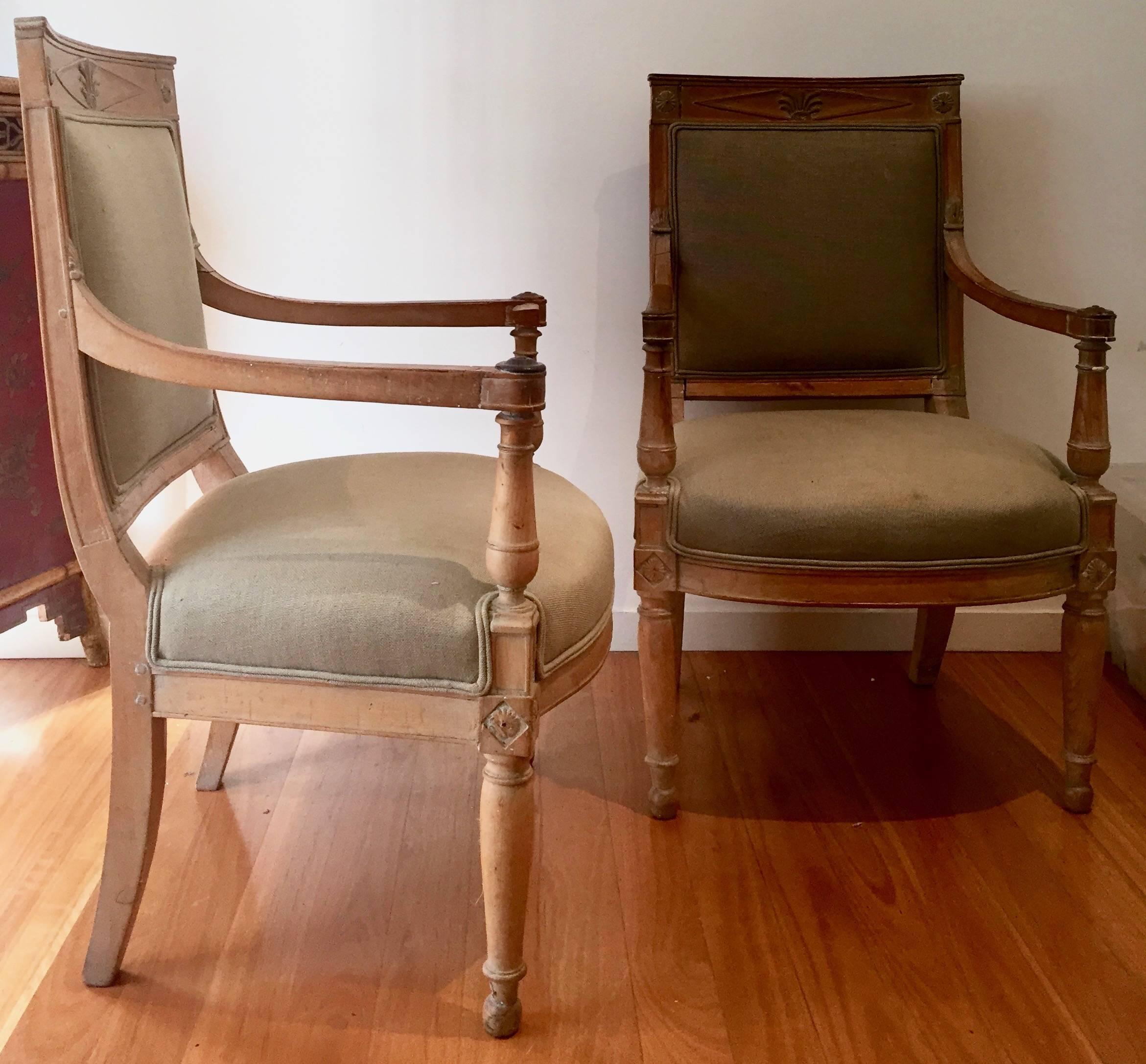 Pair of French late 18th century Directoire period fauteuils in beech with classical carved motives and sabre legs,
France, circa 1799.