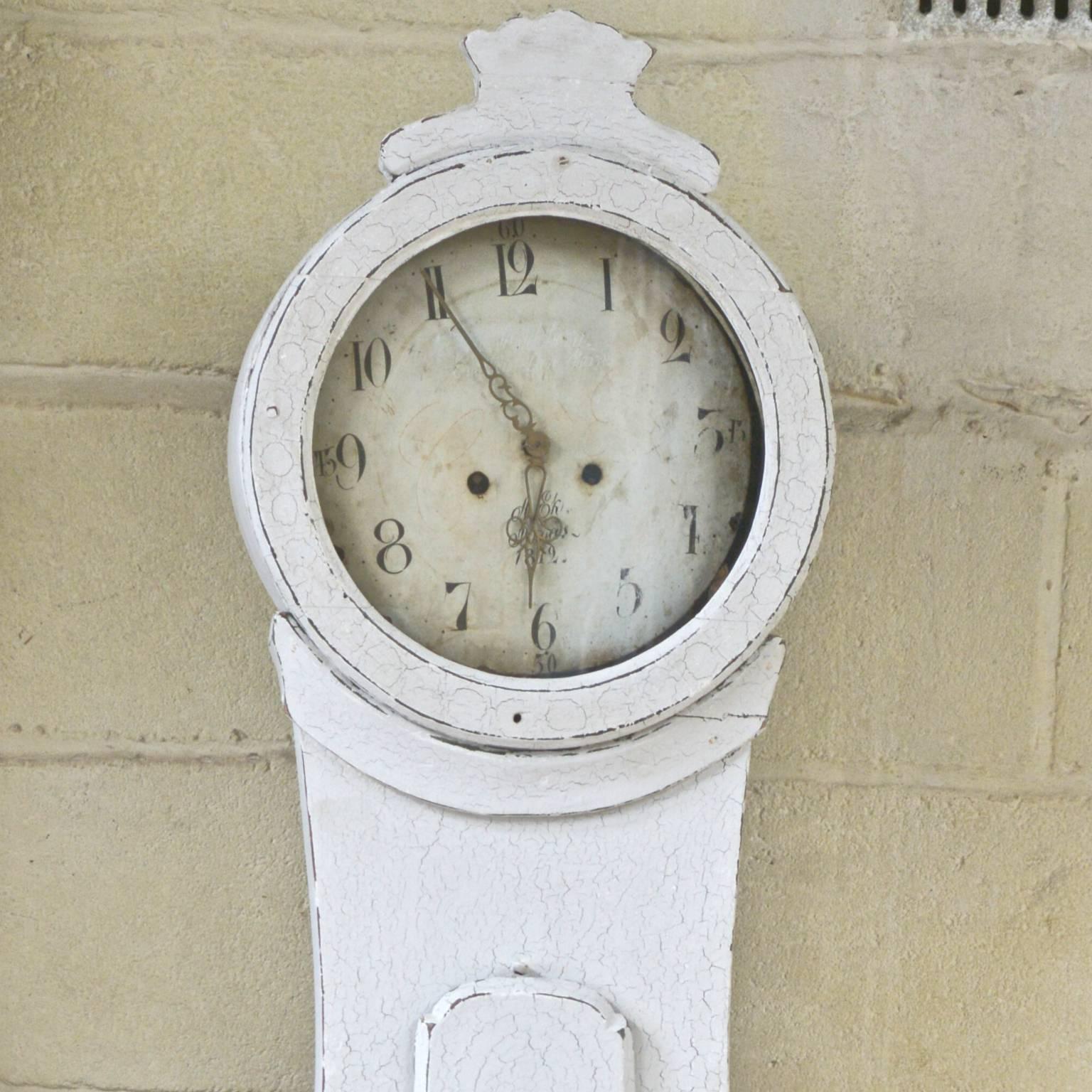 Classic country style 1800s antique Swedish Mora clock with later white paint that has developed a wonderful natural cracked patina to it and you can see earlier painted designs through the paint on the lower body.

This original 1800s Mora clock