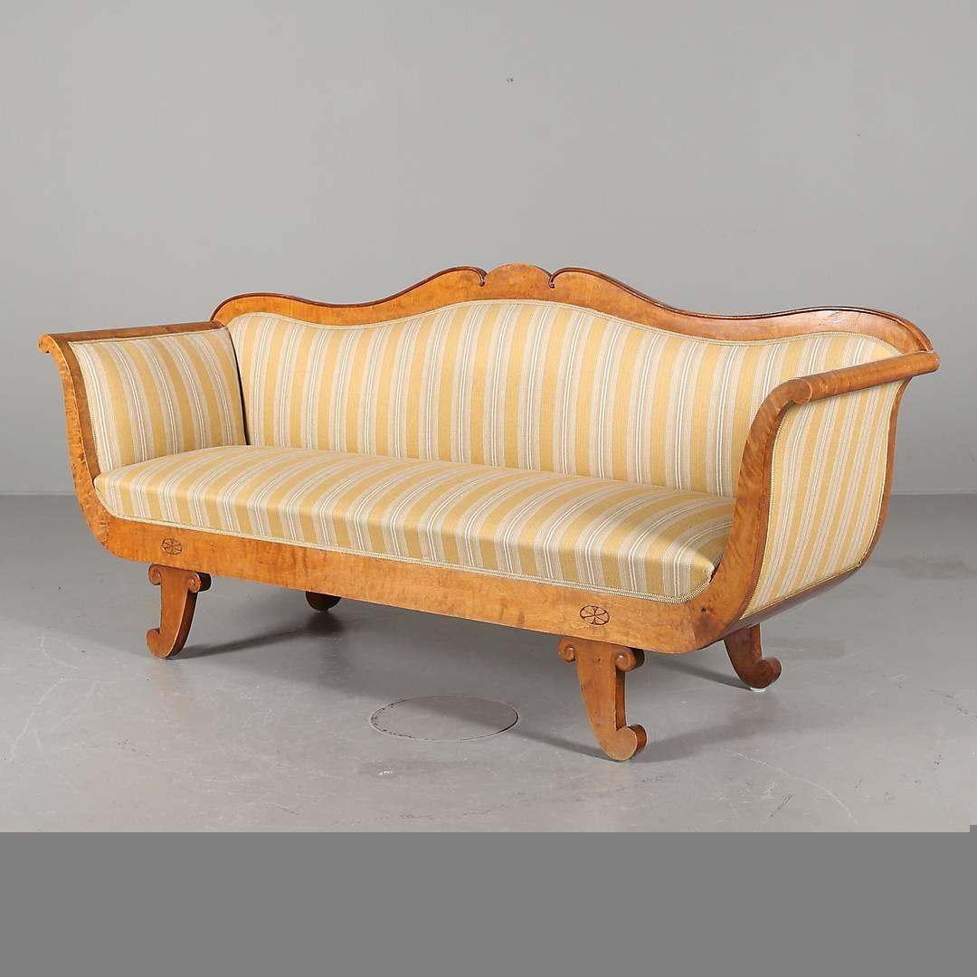 Lovely antique Swedish Biedermeier three-four-seat sofa in top grade quilted golden birch veneers in the sought after honey colour polish finish.

Lovely star motifs are placed above the front feet and the sofa a superb swoop to the arms.

It has a