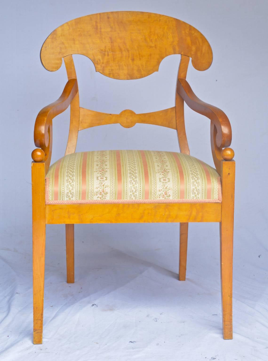 Antique Swedish Biedermeier Empire pair of carver chairs in highly quilted golden birch veneers finished in the Classic honey colour French polish finish.

They have fully webbed seats for maximum comfort and the gently curved front legs are topped