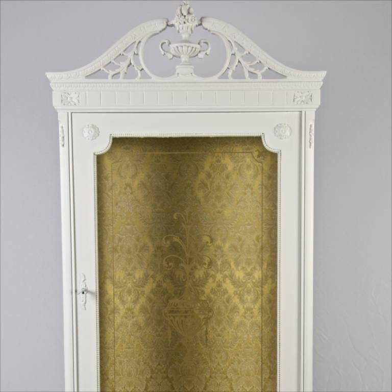 Unusual early 20th century highly carved Gustavian style display cabinet with two internal glass shelves and original fabric backboard.

Lovely Rococo style carved legs and a multitude of carved detail and an ornate cornice make this a very