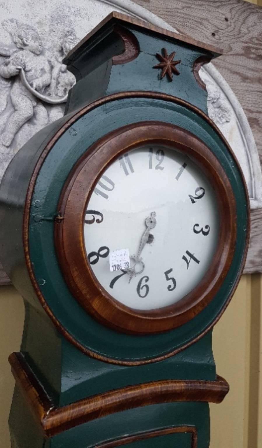 Unusual example of a decorative 1800s antique Swedish mora clock with stunning hand-painted detailing to the body and plinth with the rare flower carving and star motif on the hood.

This original 1800s mora clock has a beautiful face with a clean