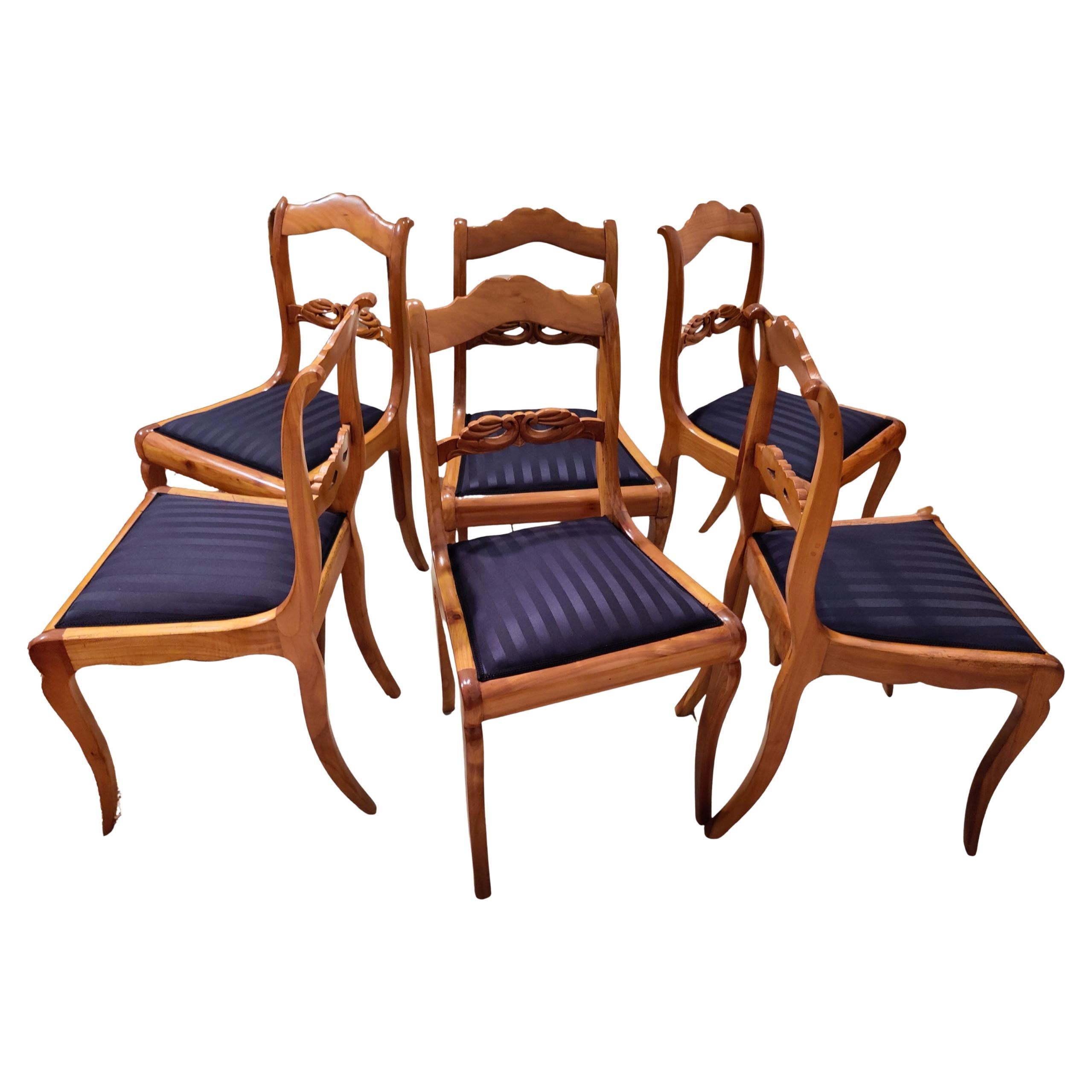 Each chair is handcrafted from solid cherrywood and reflects the refined aesthetic of the late Biedermeier period. The elegant silhouette with curved sabre legs, finely shaped seat rails and a beautifully carved backrest showcases the high