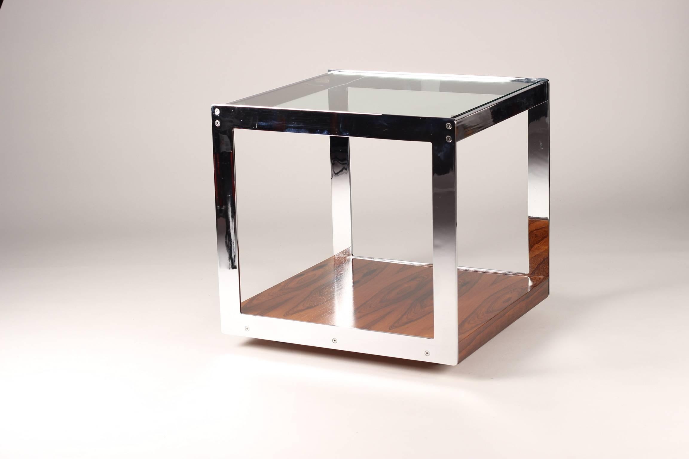 Designed by Richard Young for Merrow Associates and sold through Harrods of London in the 1970s. This rare Brazilian rosewood, chrome and glass table can be moved easily into and out of position with its concealed casters. The piece has a very