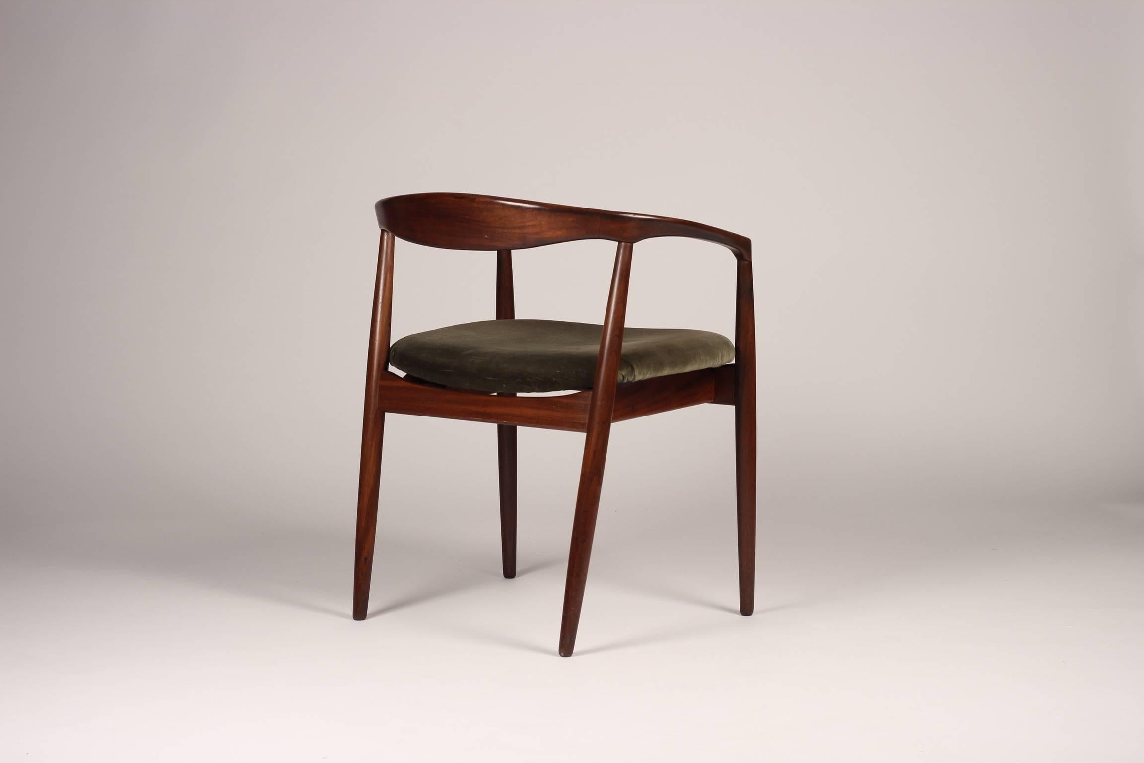 A set of four teak chairs designed by Kai Kristiansen and manufactured by Magnus Olesen in Denmark in the 1960s. The arms of this curved, round back chair bear similarities to the Paper Knife chair also by Kai Kristiansen. This model is the Troja