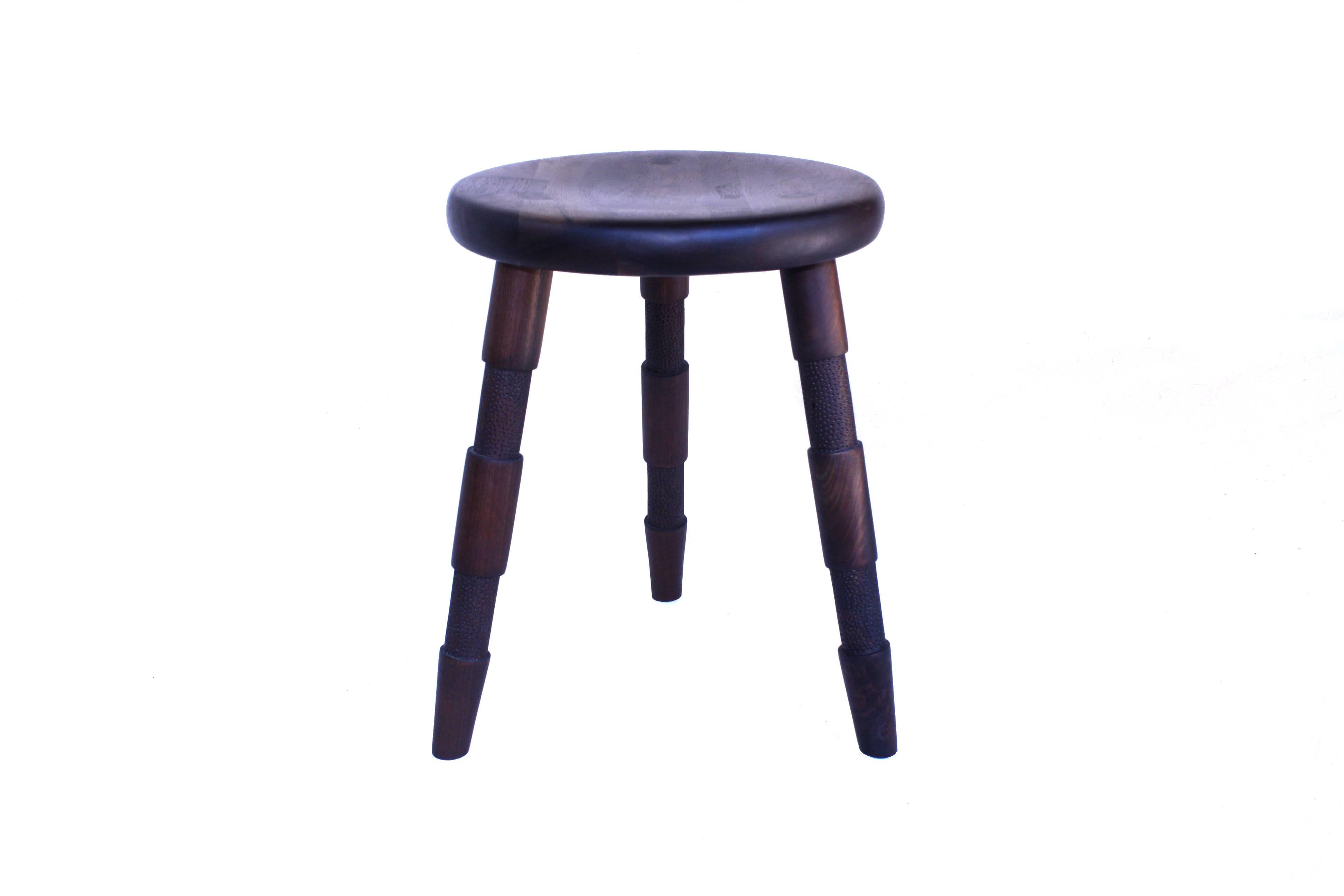 Handmade in Chicago by Laylo Studio, this solid wood stool features turned and textured legs that are joined to the hand-carved seat using through wedged, tapered tenons - a method of joinery found in Windsor chairs. The joinery locking the legs in