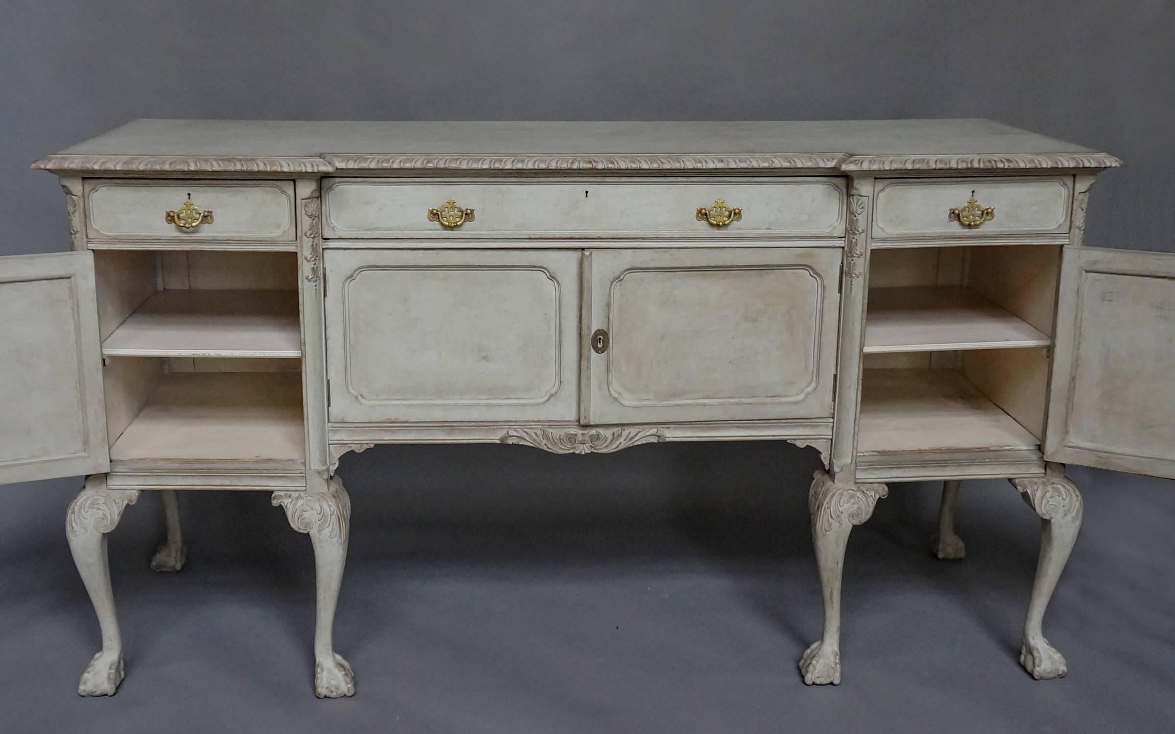 Swedish sideboard in the Rococo style, circa 1910, with four drawers and four doors. Nice carving under the shaped top and the apron. Canted corners with bellflower drops. Cabriole legs with foliate carving on the knees and ball and claw feet.
