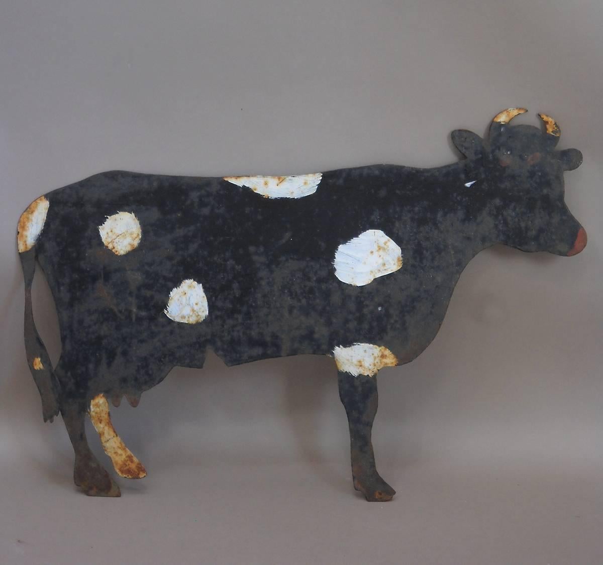 Painted cow Silhouette, Denmark, circa 1900, in sheet steel and mounted on an old wood block. The white spots and red nose and eyes are charmingly naïve.