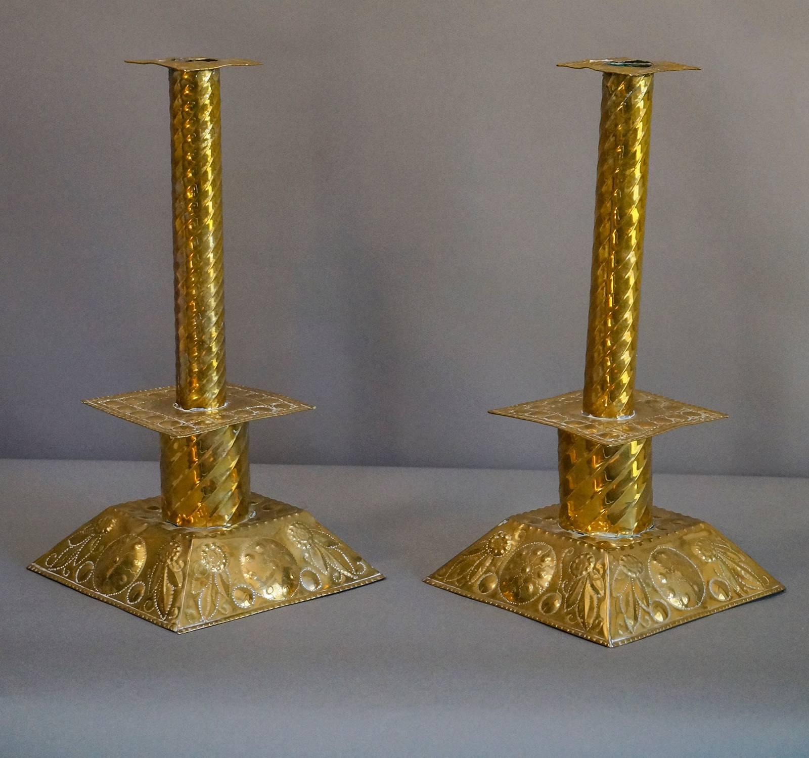 Pair of handmade Swedish candlesticks, circa 1880. The base is hammered and punched with flowers and foliage, and the stick has a twisted design. Highly polished.
