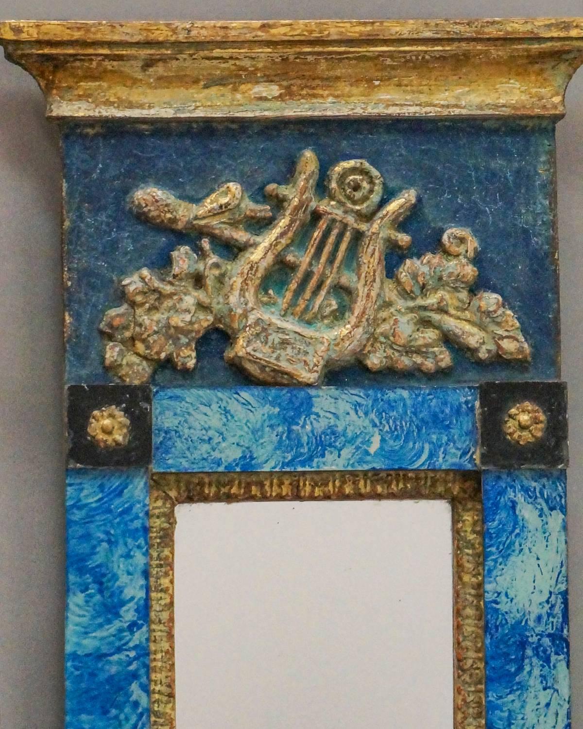 Small Swedish mirror, circa 1820, with applied classical detail on a brilliant blue ground. Reverse painted glass surrounding the mirror adds sparkle.