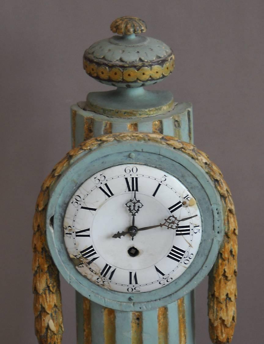 Swedish mantel clock in the Louis XVI style, circa 1800. Clockworks are mounted in an open-backed column with carved swag and urn. Original painted surface and clockworks.