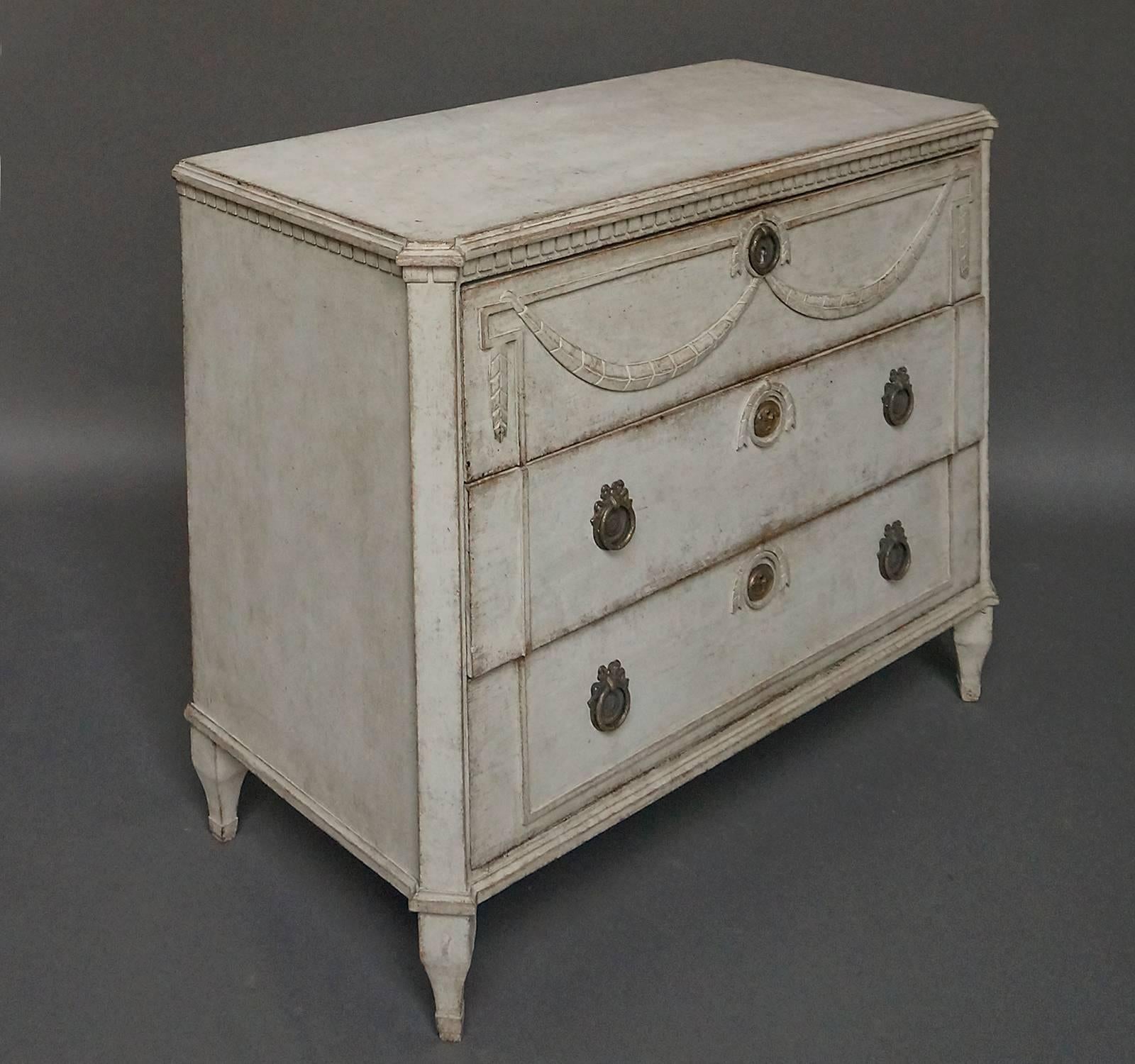 Swedish neoclassical chest of drawers, circa 1860, with remarkable carving on the drawer fronts. Dentil molding under the shaped top and above the canted corner posts. Square legs with a curved taper.