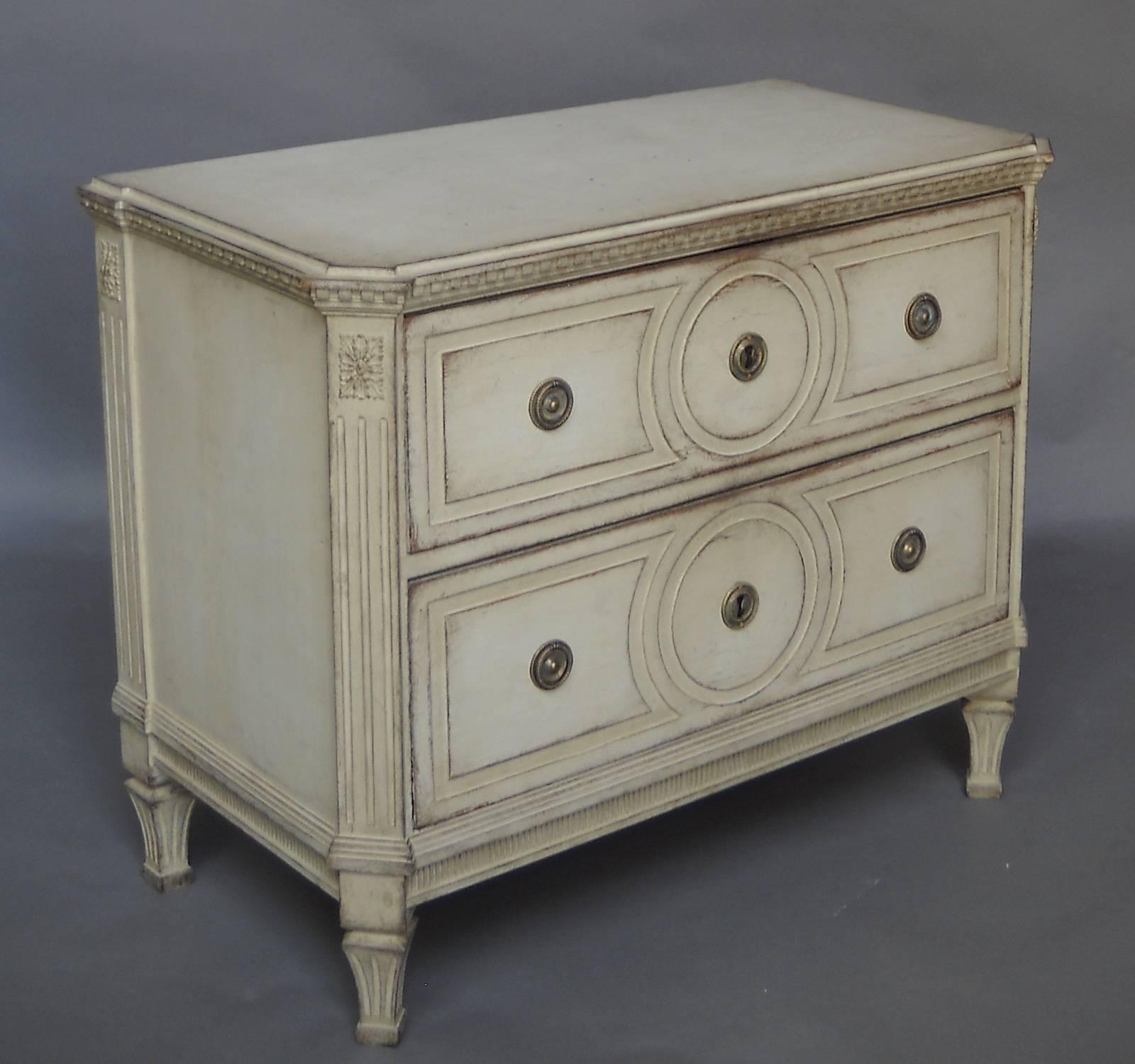 Gustavian chest of two drawers, Sweden, circa 1820, with chamfered corners, fluted corner posts and dentil molding around the top. Raised panel detail and brass fittings on each drawer front. All original with no repairs.