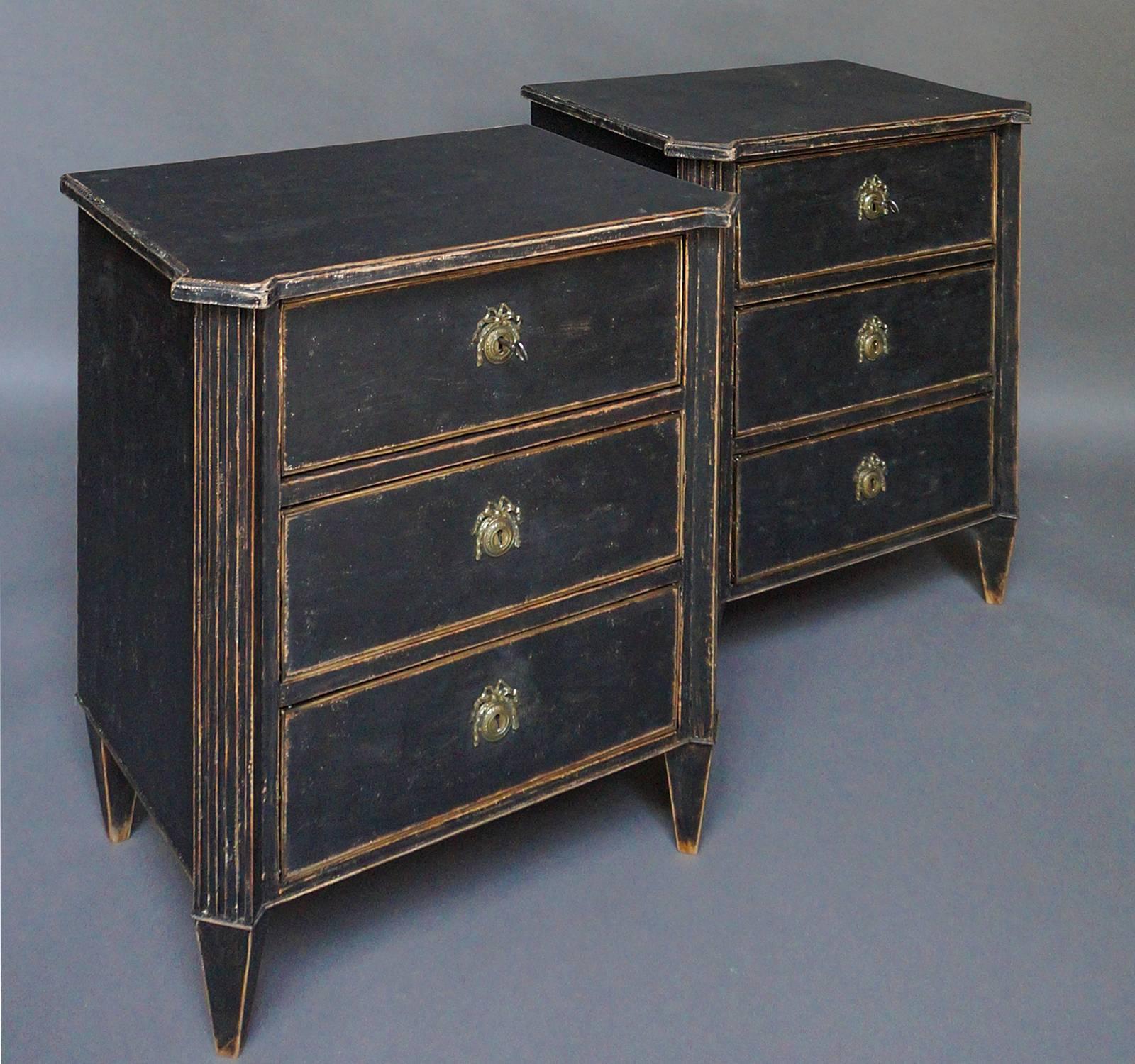 Black painted pair of small three drawer chests, Sweden circa 1880, in the Gustavian Style. Shaped tops, canted corners with reeded corner posts, and tapering square legs.