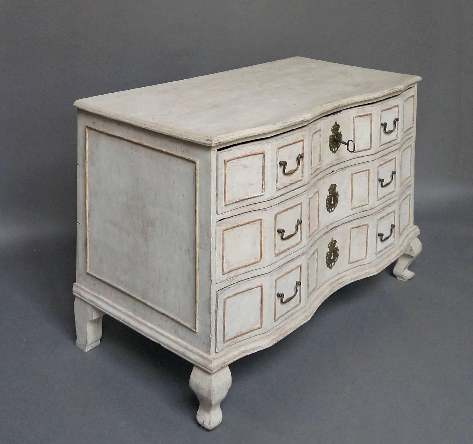 Period Swedish Rococo chest of drawers, circa 1790, with bow-front form. Three-drawers with framed panels under a shaped top. Original brass escutcheons with crown detail. Large framed panels on the sides above compressed cabriole legs.