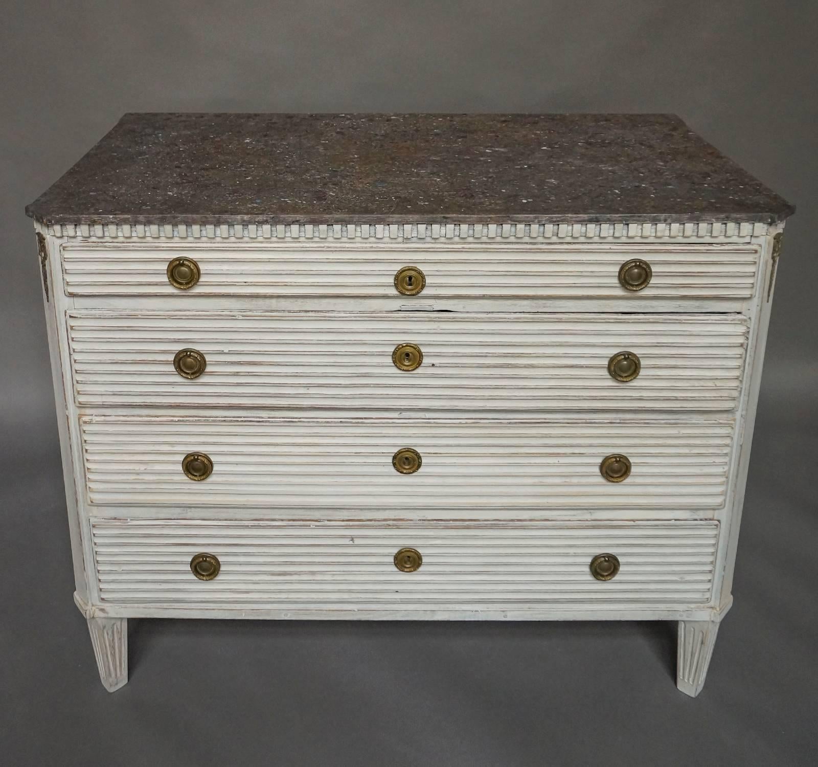 Late Gustavian chest of drawers, Sweden, circa 1800, with faux porphyry top. Each of the four drawer fronts has raised reeding and original brass pulls and escutcheons. Dentil molding around the top and canted corners with brass detail. The incised