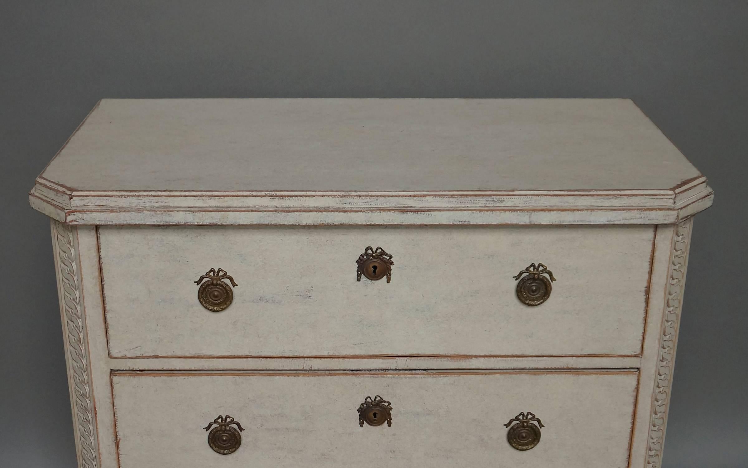 Swedish three-drawer chest, circa 1880, in the neoclassical style with shaped top and canted corners. Guilloche carving runs from top to bottom on the sides. Tapering square legs.