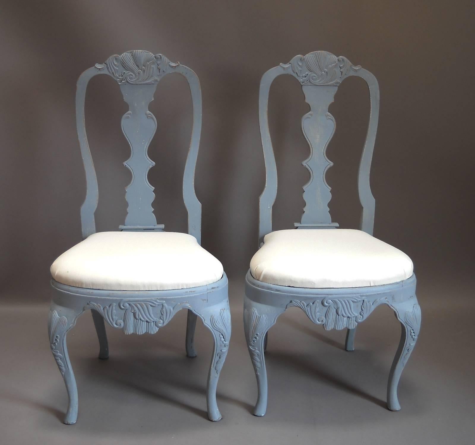 Set of eight dining chairs, Sweden, circa 1880, in the Rococo style with slip seats and elaborate carving.