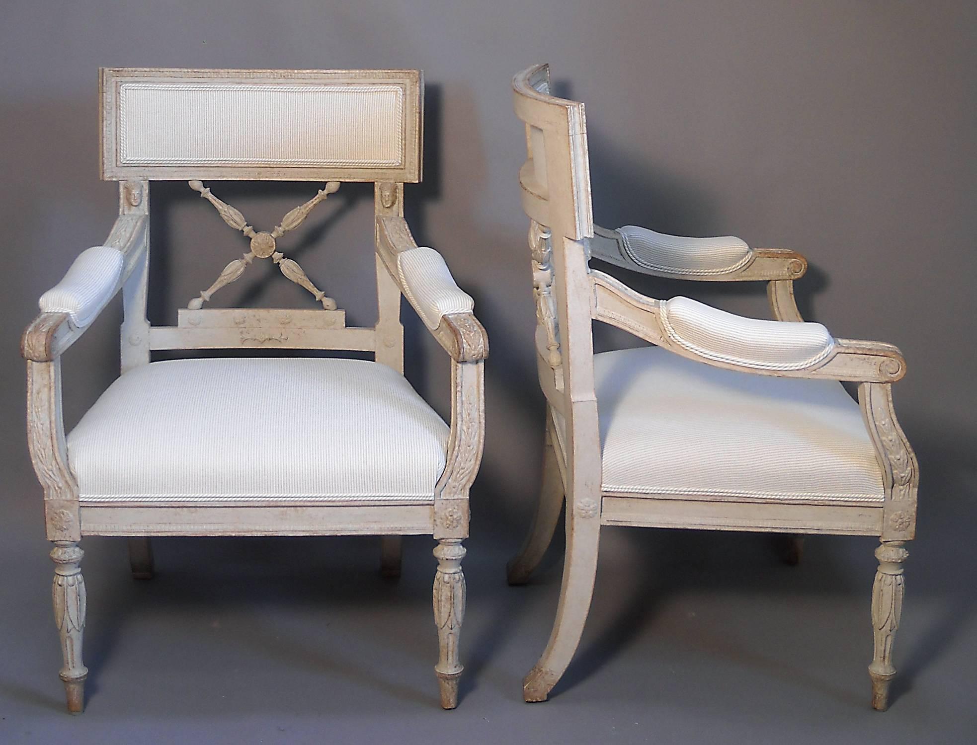 Pair of Swedish armchairs from the Empire period, circa 1860, with upholstered seats and backs. Carved Egyptian motifs include lotus flowers and archaic heads. Excellent original condition with new upholstery.