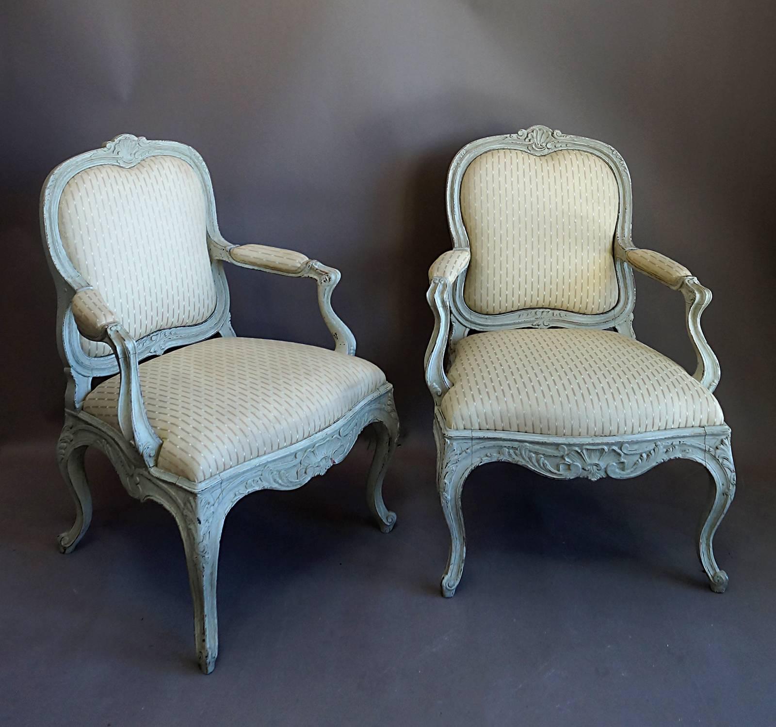 Pair of Swedish armchairs, circa 1880, with frames carved in the Rococo style. The curved crest has a central shell motif with foliate detail on either side. The same elements decorate the lower portion of the frame and the legs. Scrolled feet,