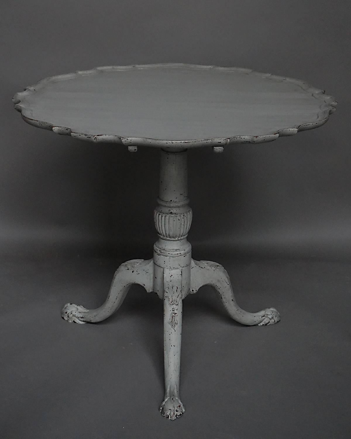 Tilt-top table, circa 1840 with pedestal base with carved cabriole legs. The top has a shaped, pie-crust edge.