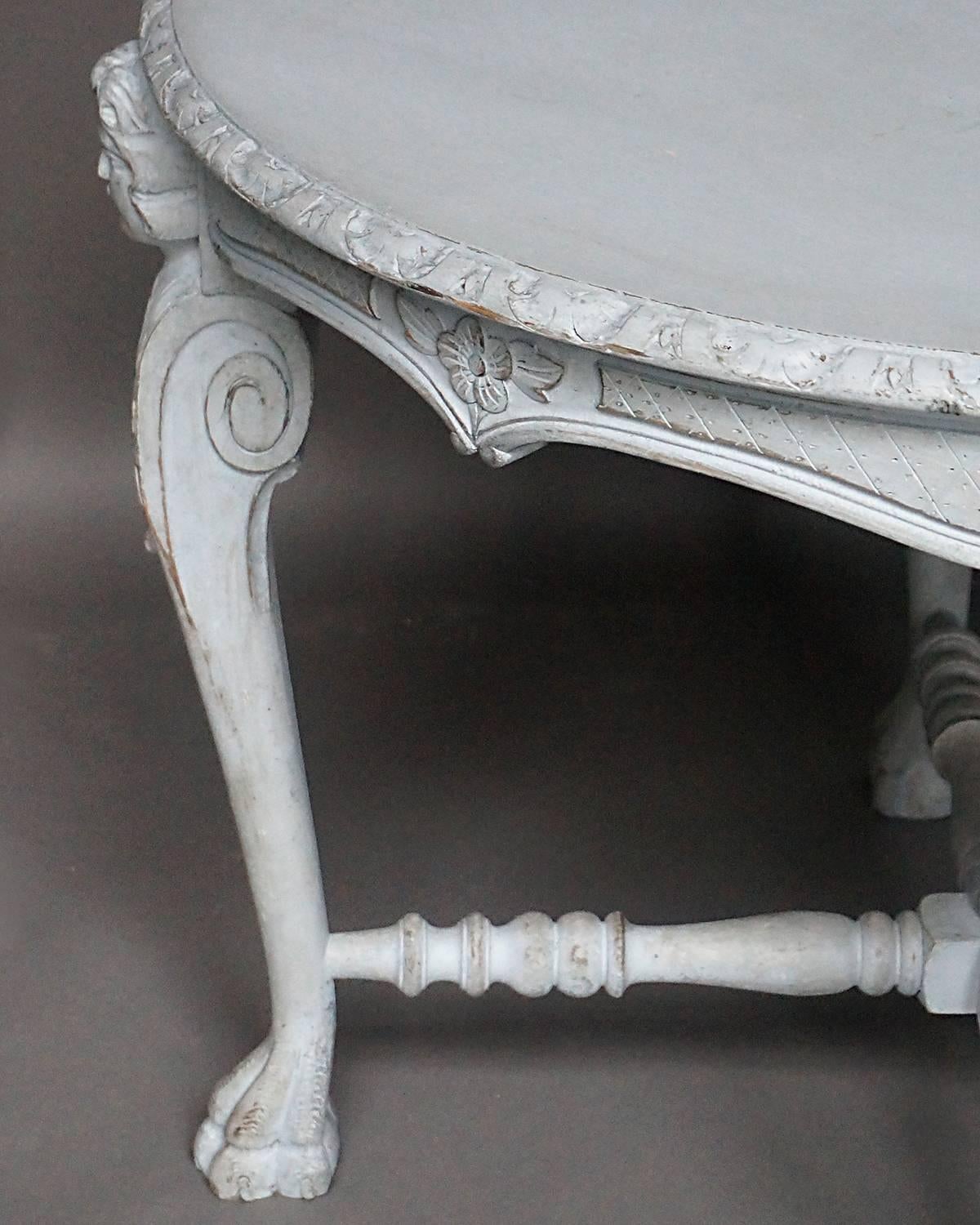 Round side table, Denmark, circa 1880, having a shaped top and four cabriole legs with classical figures and acanthus leaves at the top and terminating in lions paw feet. The aprons are carved with a lattice pattern centred with a simple rose. The