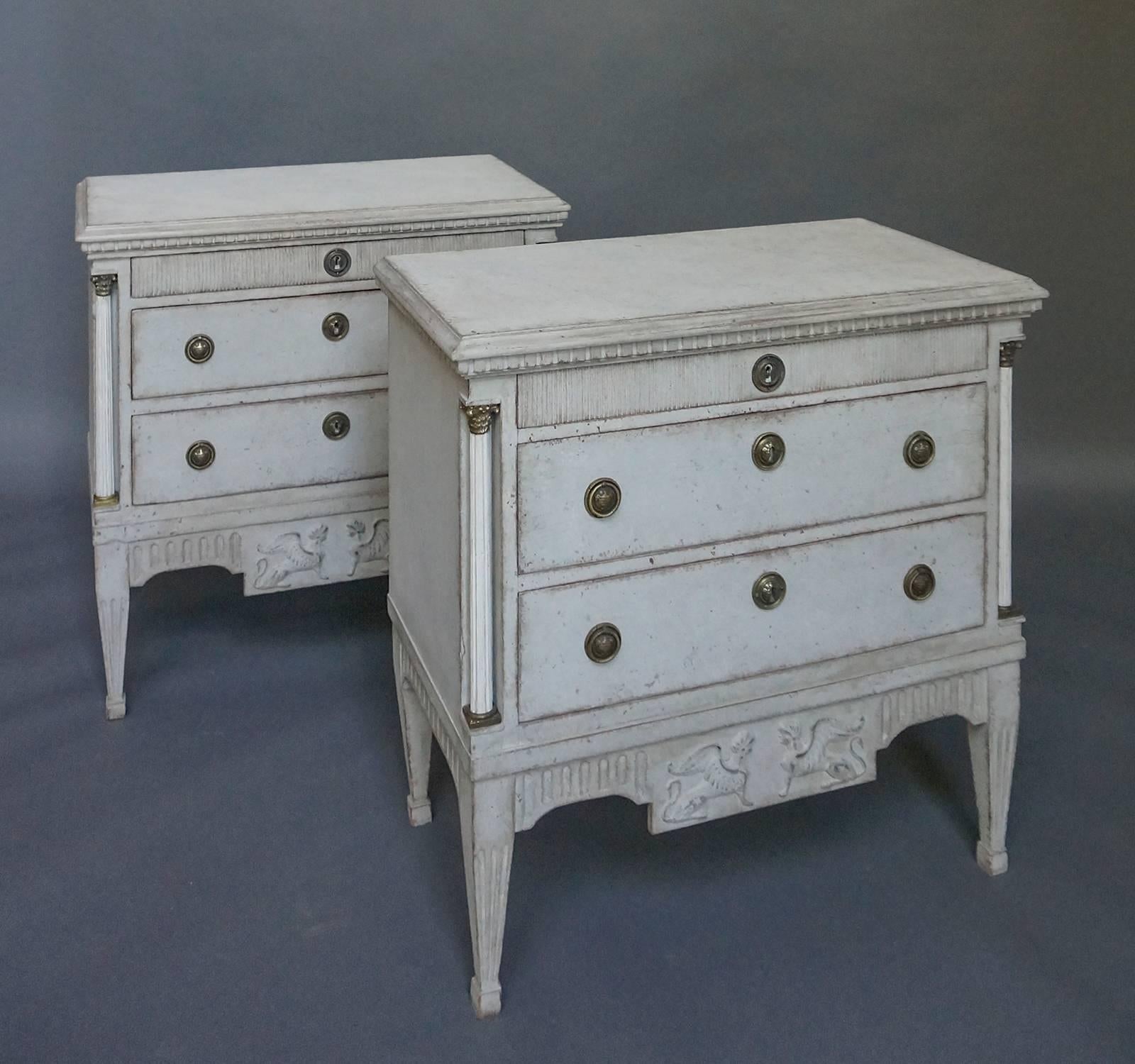 Pair of Swedish neoclassical style commodes, circa 1880, with fully round columns at the corners. Dentil molding around the top and vertical reeding on the top drawer front. In the center of the aprons are panels with facing sphinxes which guard the