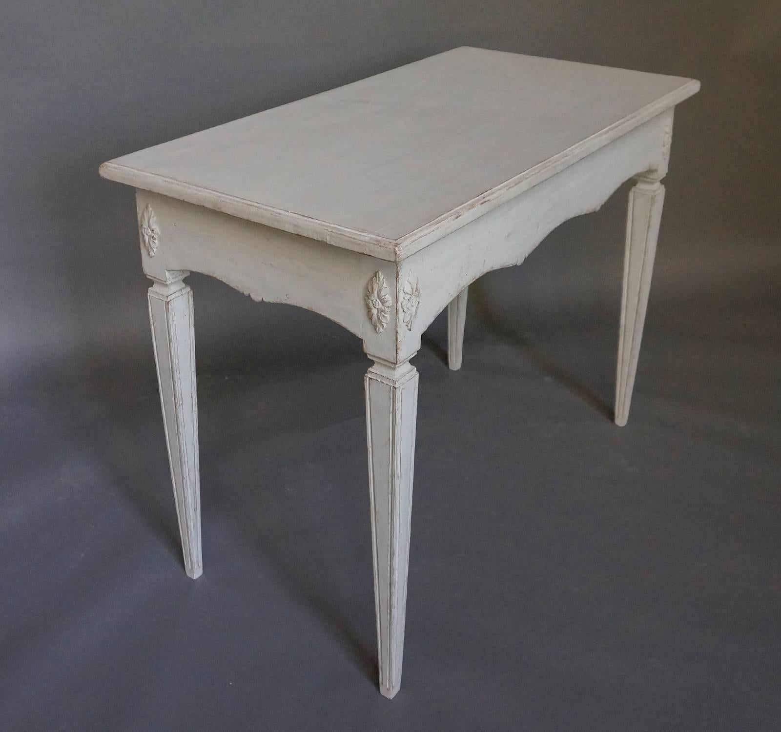 Freestanding table (finished on all sides) in the Gustavian Style, Sweden circa 1860, with scalloped apron. The tapering square legs have applied florets at the tops.