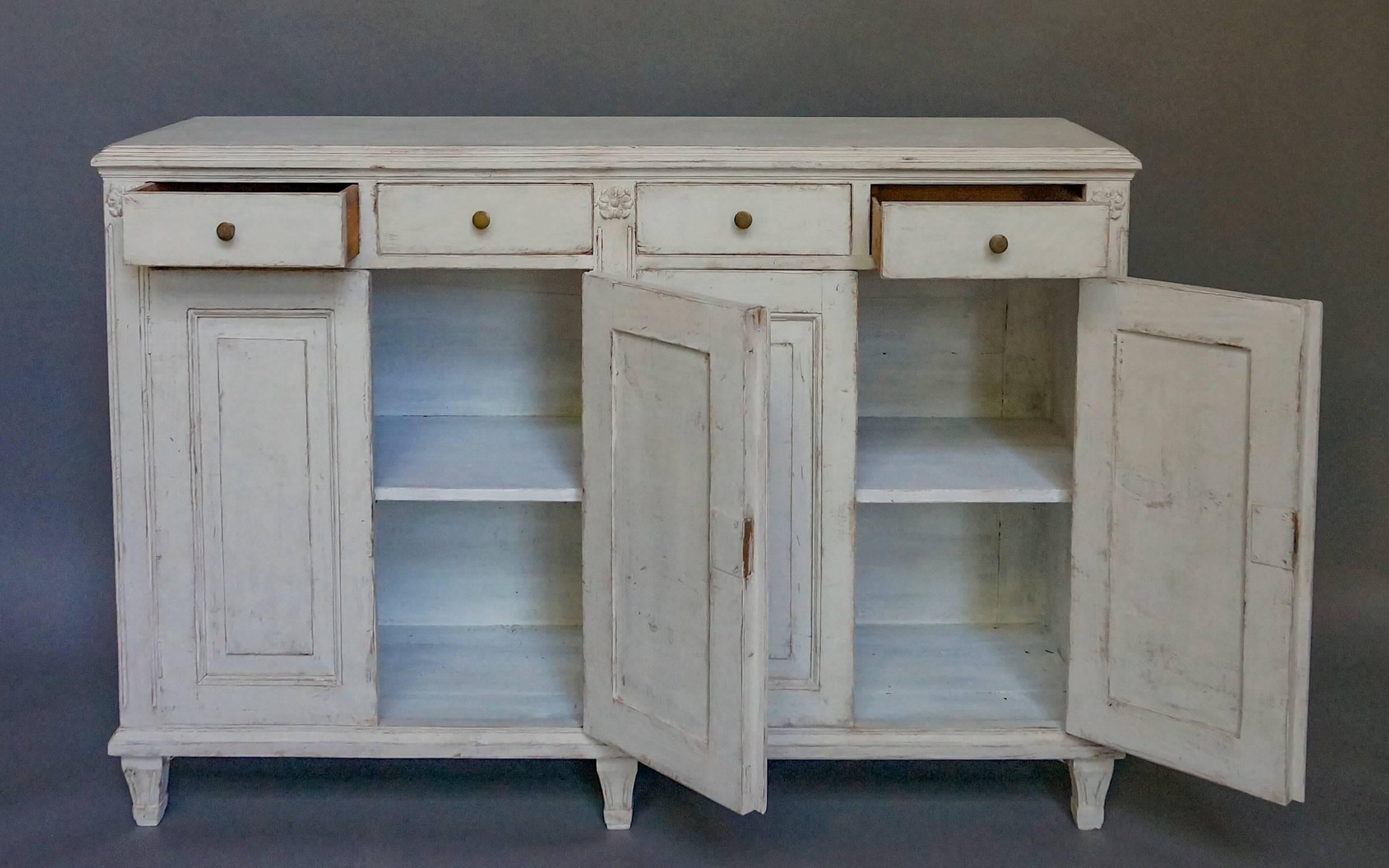 Sideboard in the Gustavian style, Sweden, circa 1840, with applied rosettes. Four drawers over four raised panel doors. One interior shelf, tapered square feet.