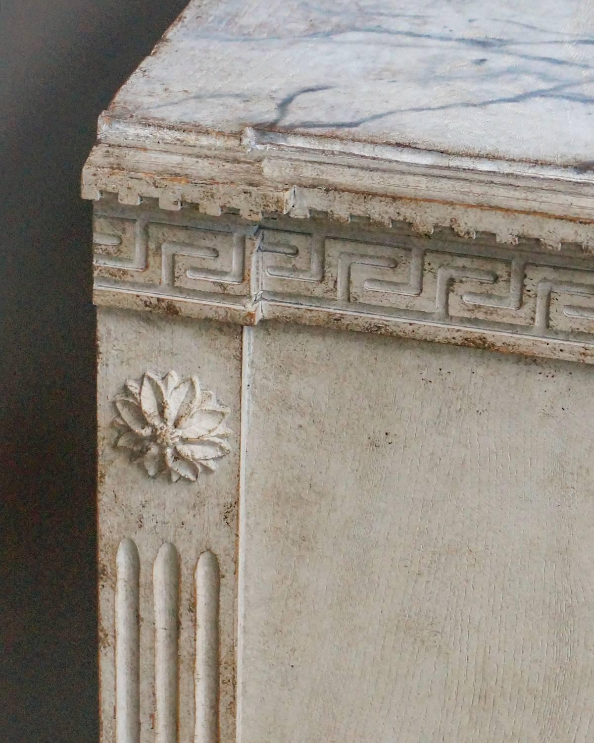 Period neoclassical chest of drawers, Sweden, circa 1790. Greek key frieze under a shaped top with faux marble painting. Canted corners at the front, reeding on front and back corner posts and applied rosettes at the tops. Tapering square legs.