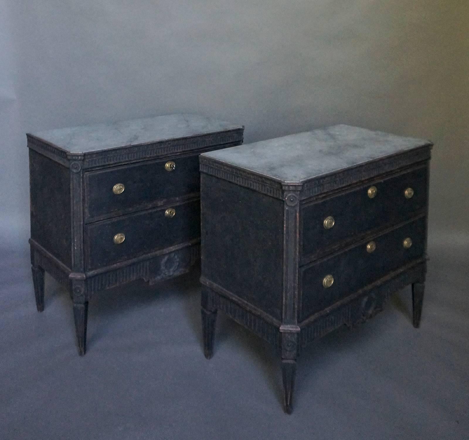 Pair of Swedish two-drawer chests, circa 1870, in the Gustavian style. A double row of dentil molding appears under the marbled top. Canted corners have reeded corner posts with applied rondels at the top and ending in tapering square feet. The