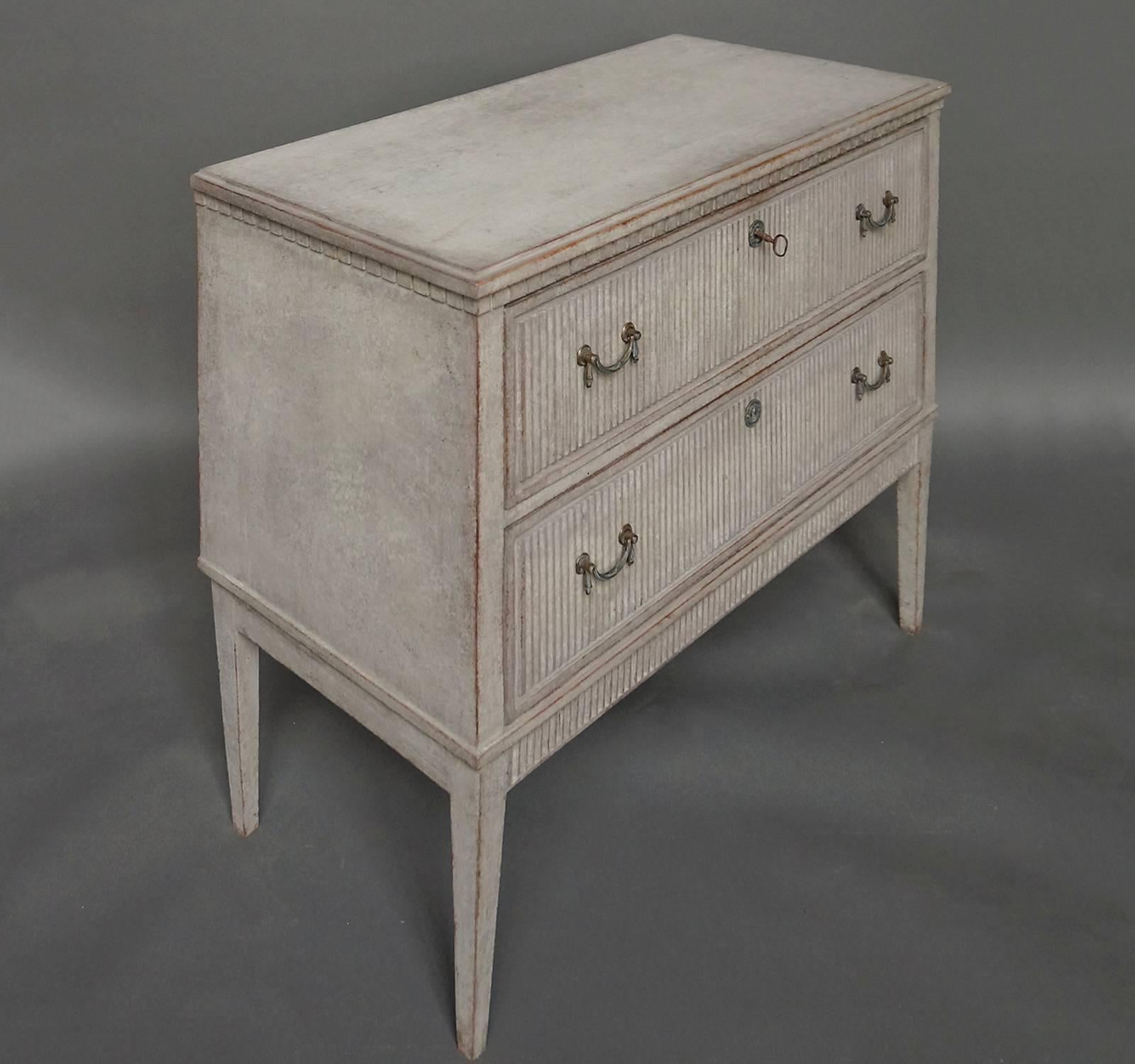 Chest of drawers, Sweden, circa 1880, with dentil molding under the stepped top. Reeded drawer fronts with original hardware. Tapering square legs with reeded apron at the front.