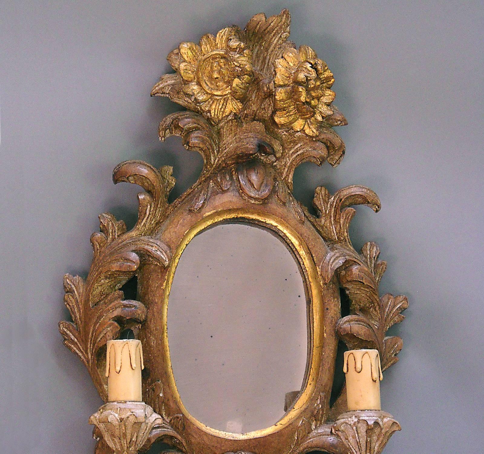 Carved wood and composition Danish sconce in the Rococo style with mirror and two candle holders. Highly decorative with blossom and fruit details.