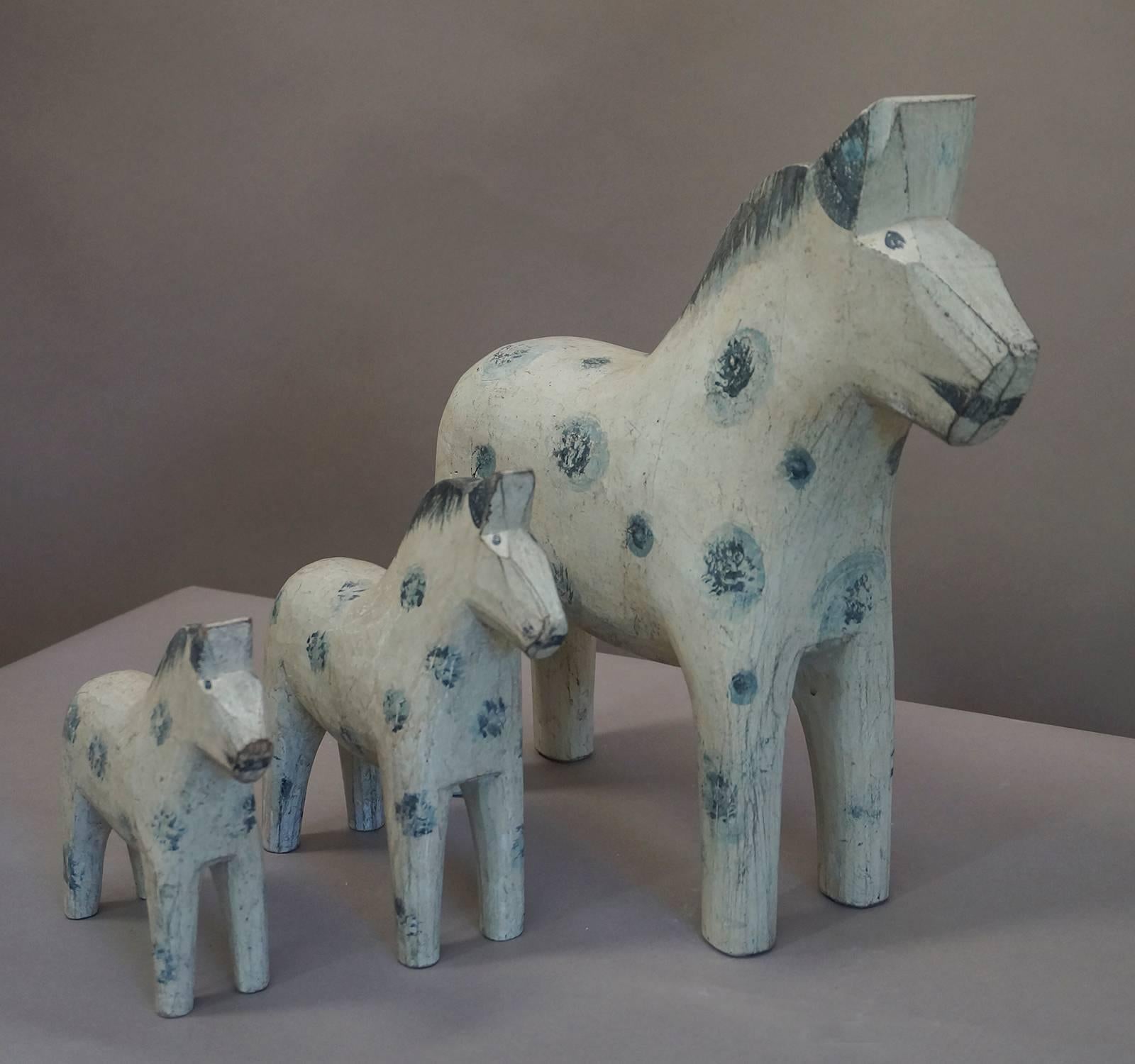 Family of three hand-carved and hand-painted Dala horses, Sweden, circa 1880. They range in size from 14 to 6½” tall and all have similar white paint with blue polka dots.