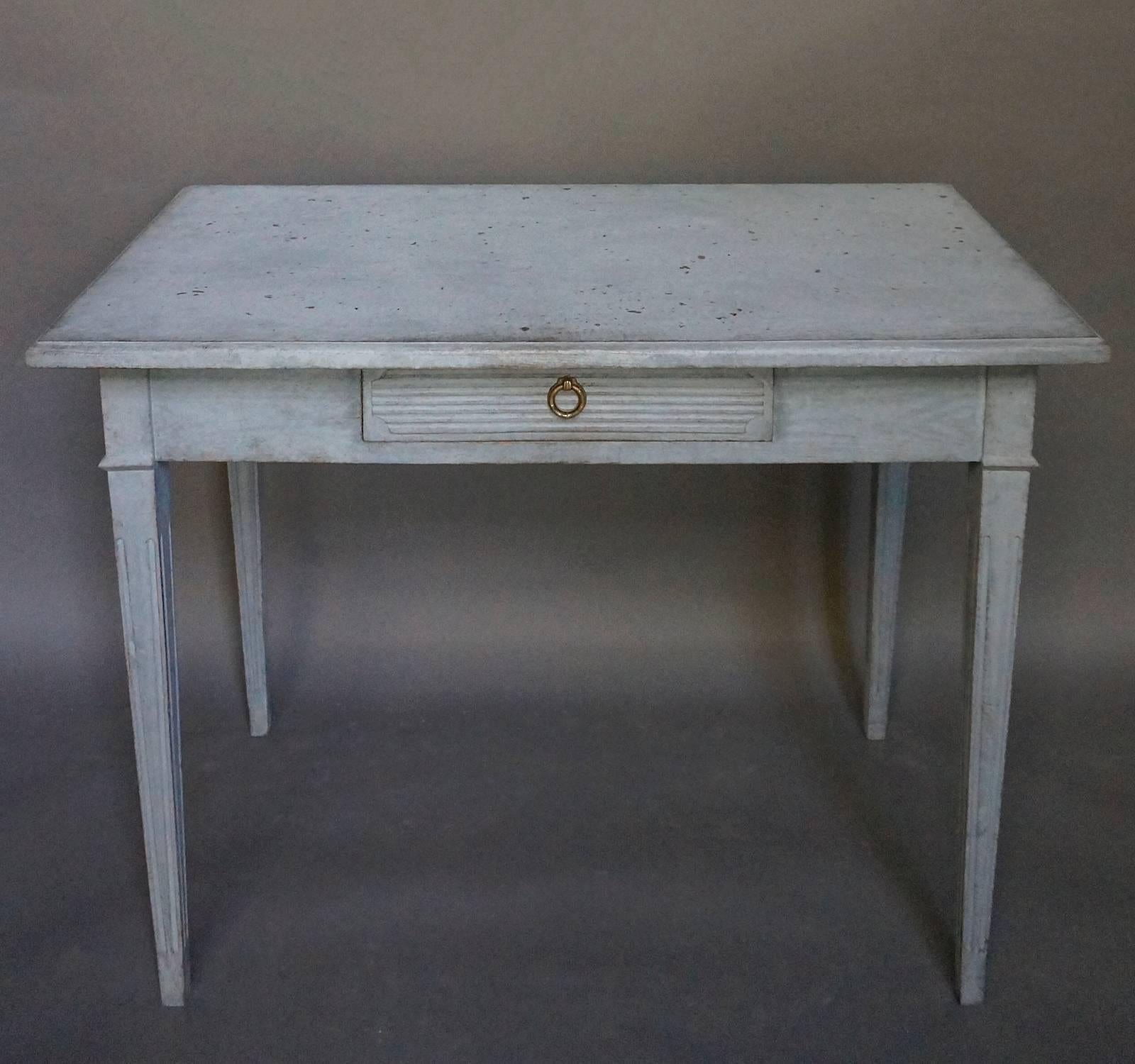 Side table, Sweden, circa 1860, with neoclassical detail. The single apron drawer has a shaped panel of horizontal reeding, and the tapering legs are also reeded.