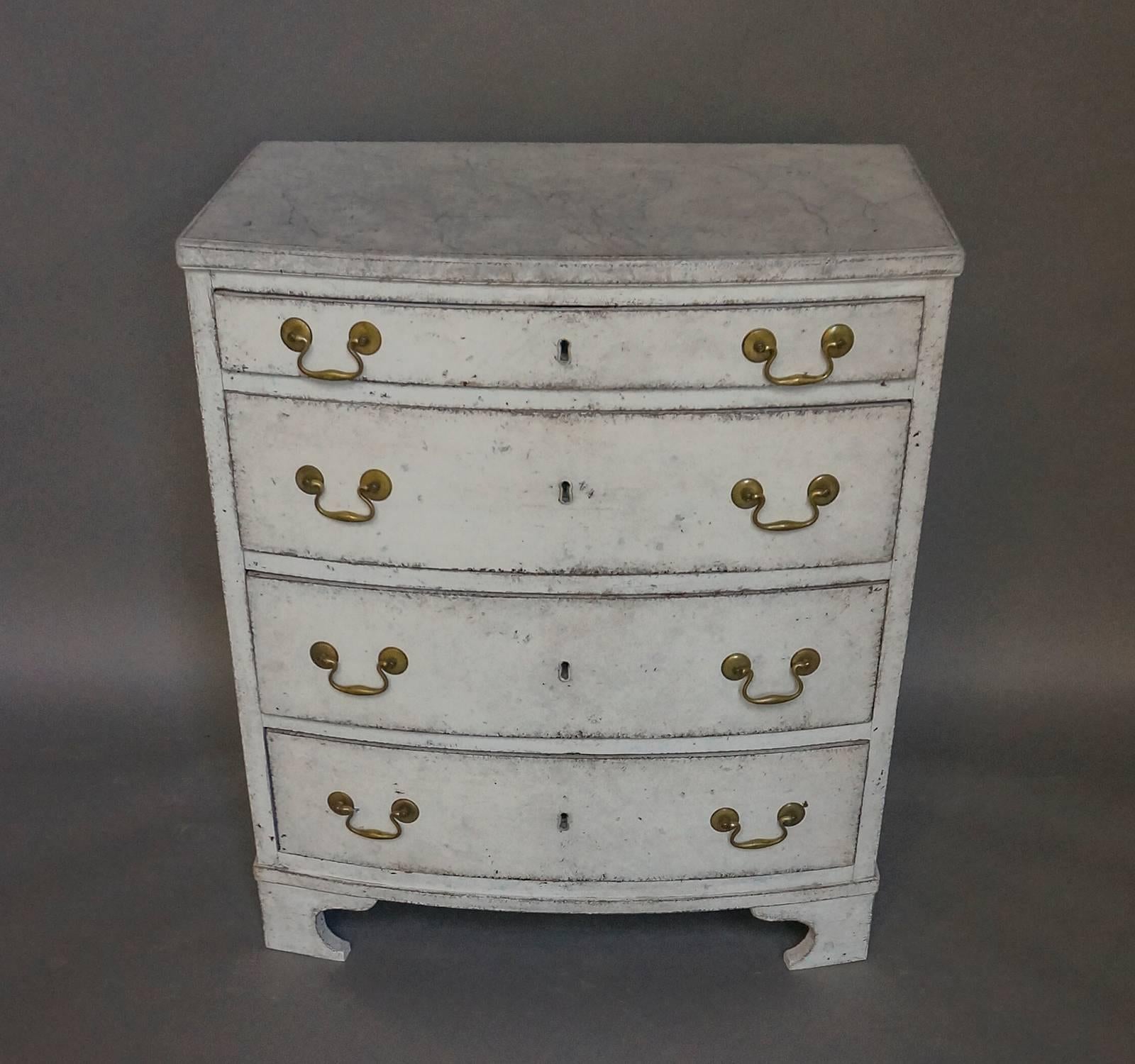 Swedish chest of drawers, circa 1810, with curved form and gray marbled top and shaped bracket base. The four drawers retain their original locks. Small size makes this piece useful in many situations.