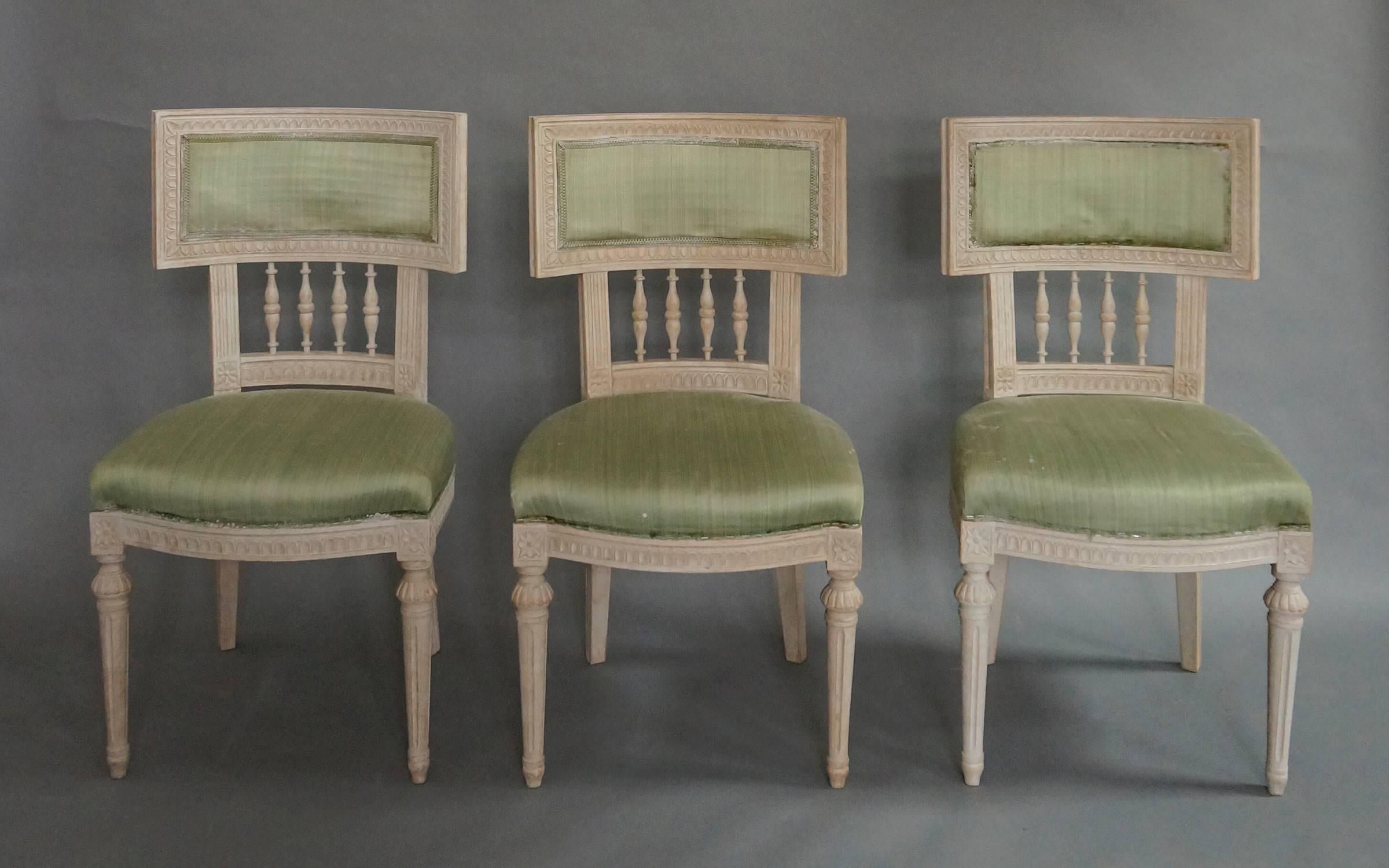 Set of eight Lindome dining chairs, Sweden circa 1920, with curving, klismos backs augmented with turned spindles. The frame is decorated with lambs tongue molding, and the front legs are turned and reeded. Upholstered backs and seats. Seat height,