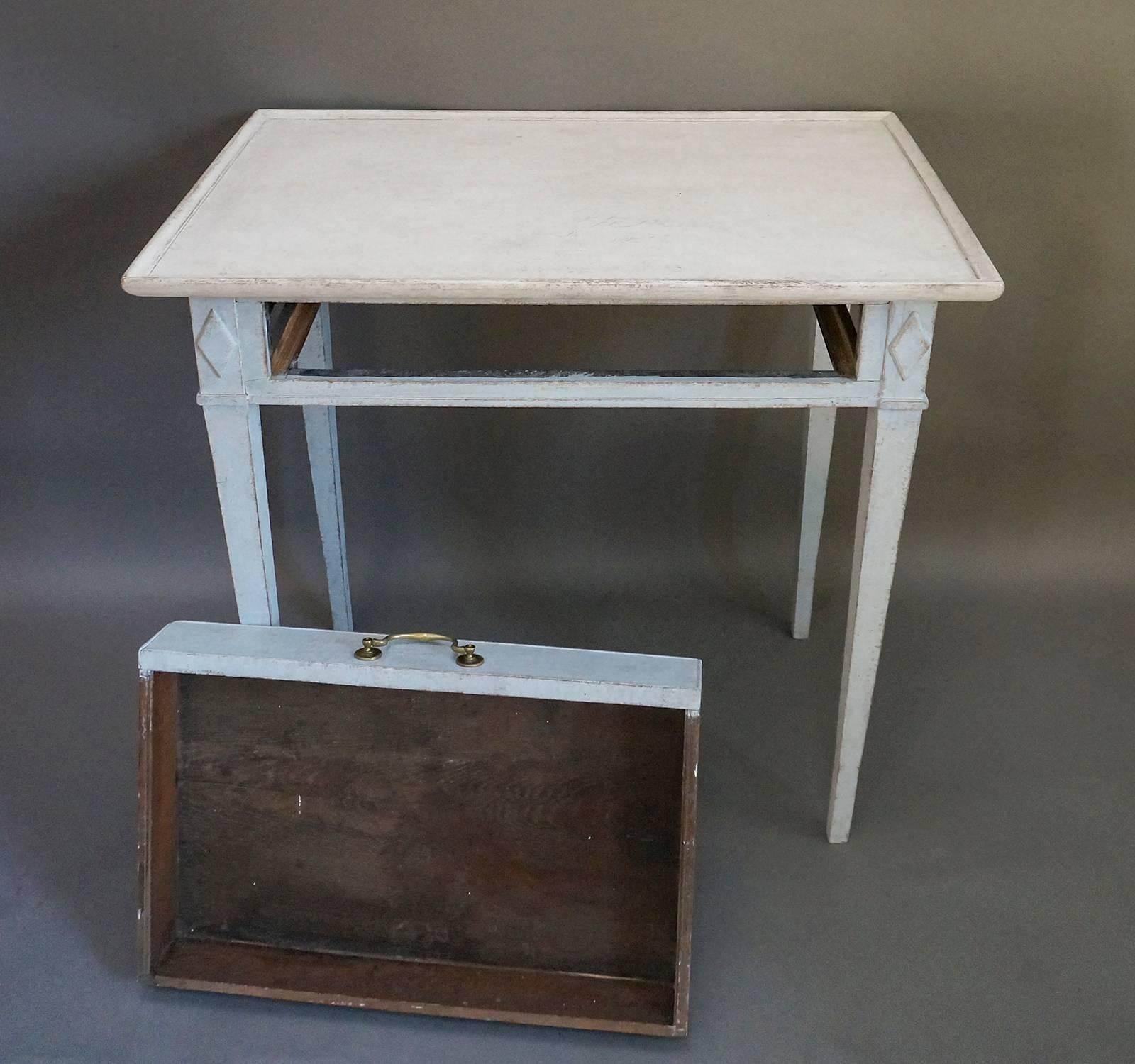 Small side table from the late Gustavian period, Sweden circa 1820. Tapering square legs with raised lozenges on the corner blocks. Single apron drawer with original brass pull.