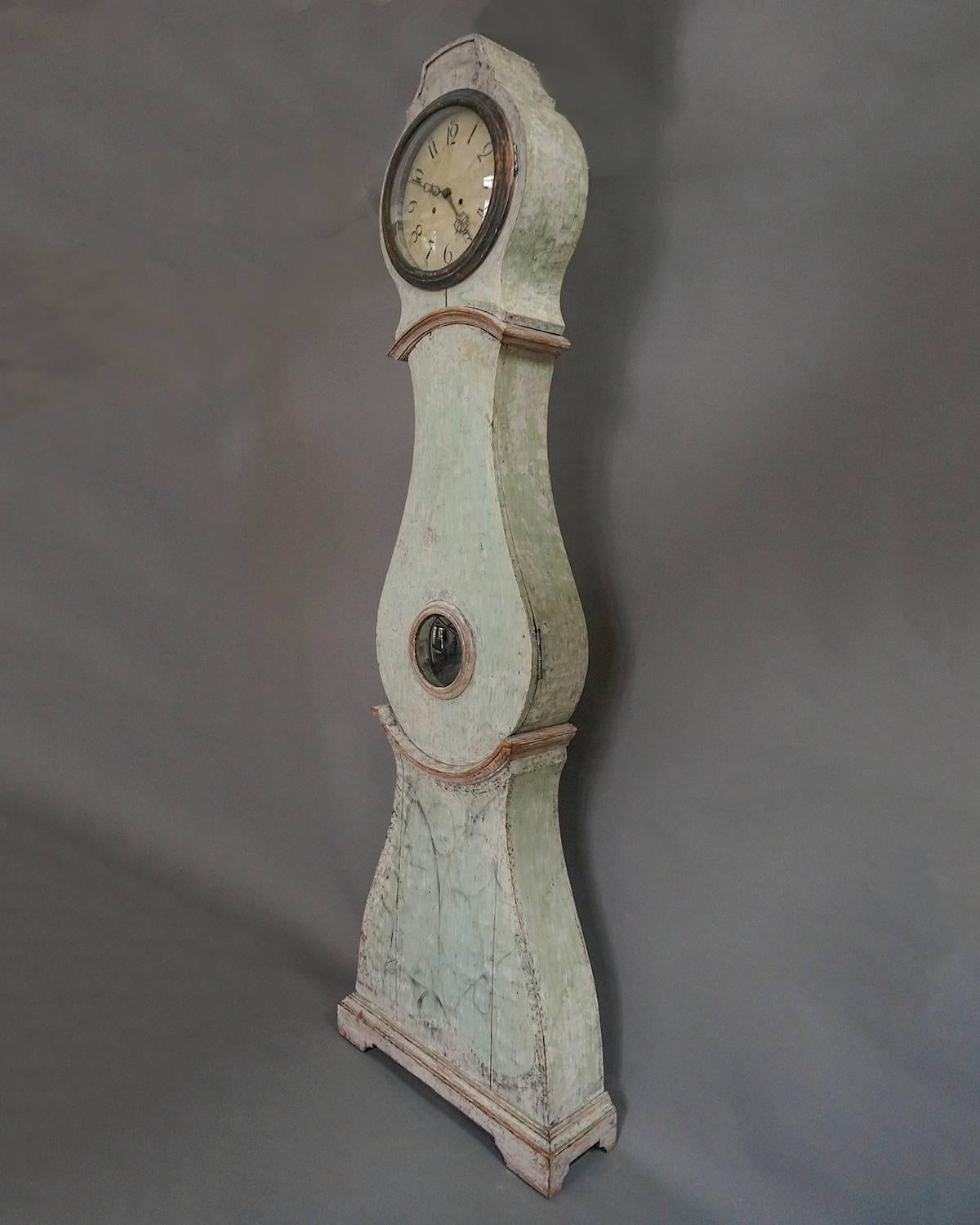 Swedish Mora clock, circa 1800, dry scraped to its original pale green painted surface and retaining traces of earlier decorative black paint. Hand-painted dial with unusual steel hour and minute hands. Newly cleaned and adjusted.