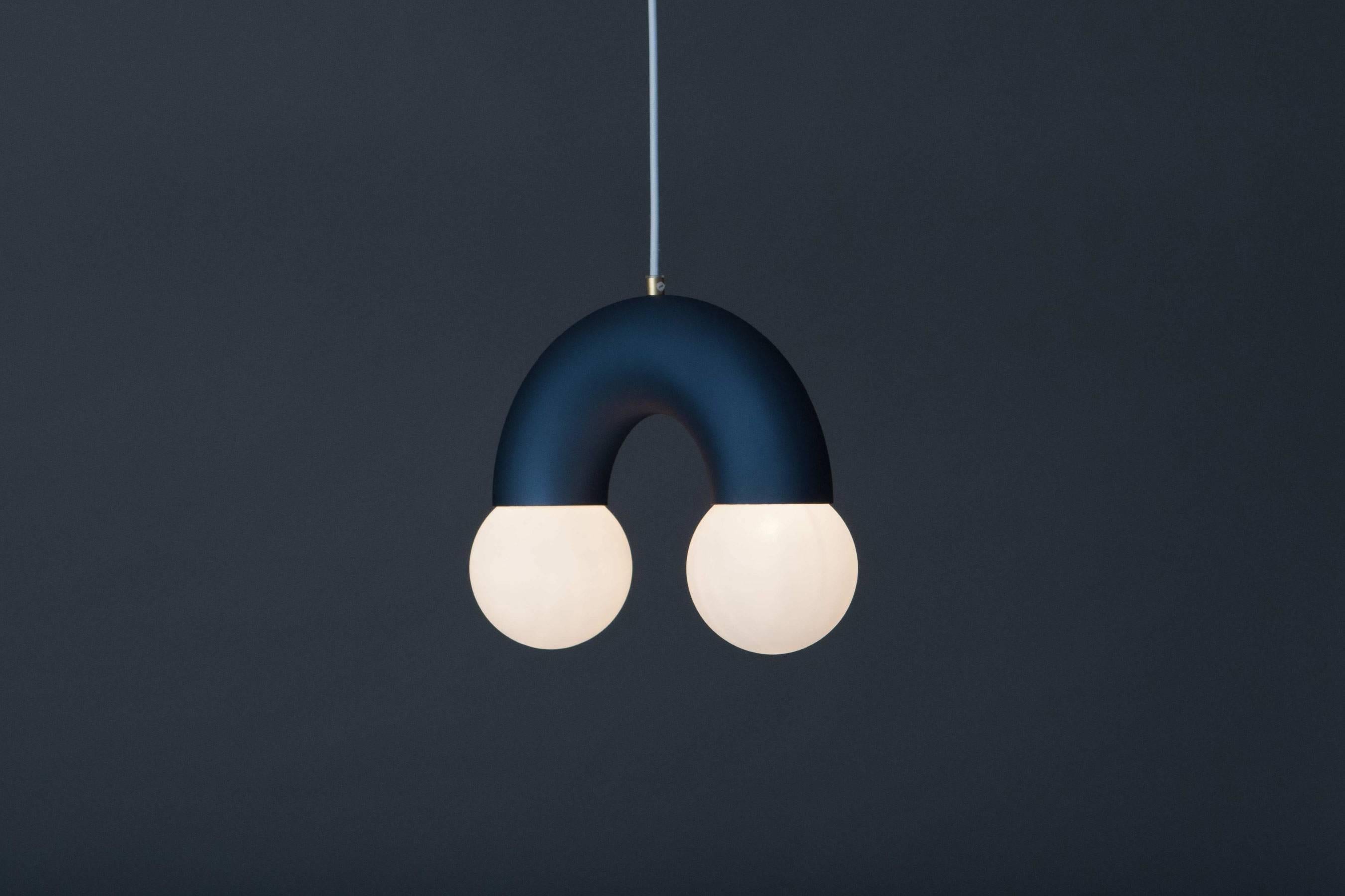 Anodised sandblasted and bent aluminium tube as the main structure with 10cm ø glass globes. The colour of lamp is available in steel blue and gold and natural steel. Brass fixture for holding the textile cable.